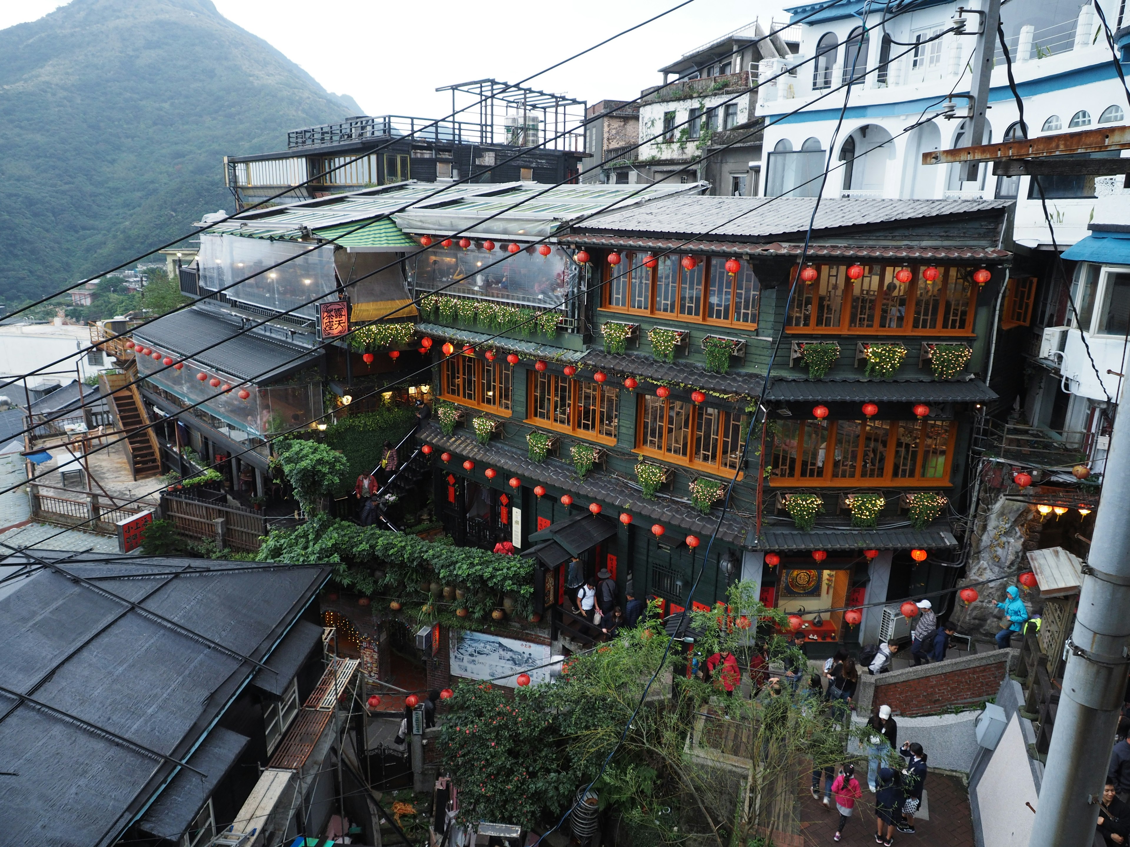 Edificios tradicionales adornados con faroles rojos en una ciudad montañosa