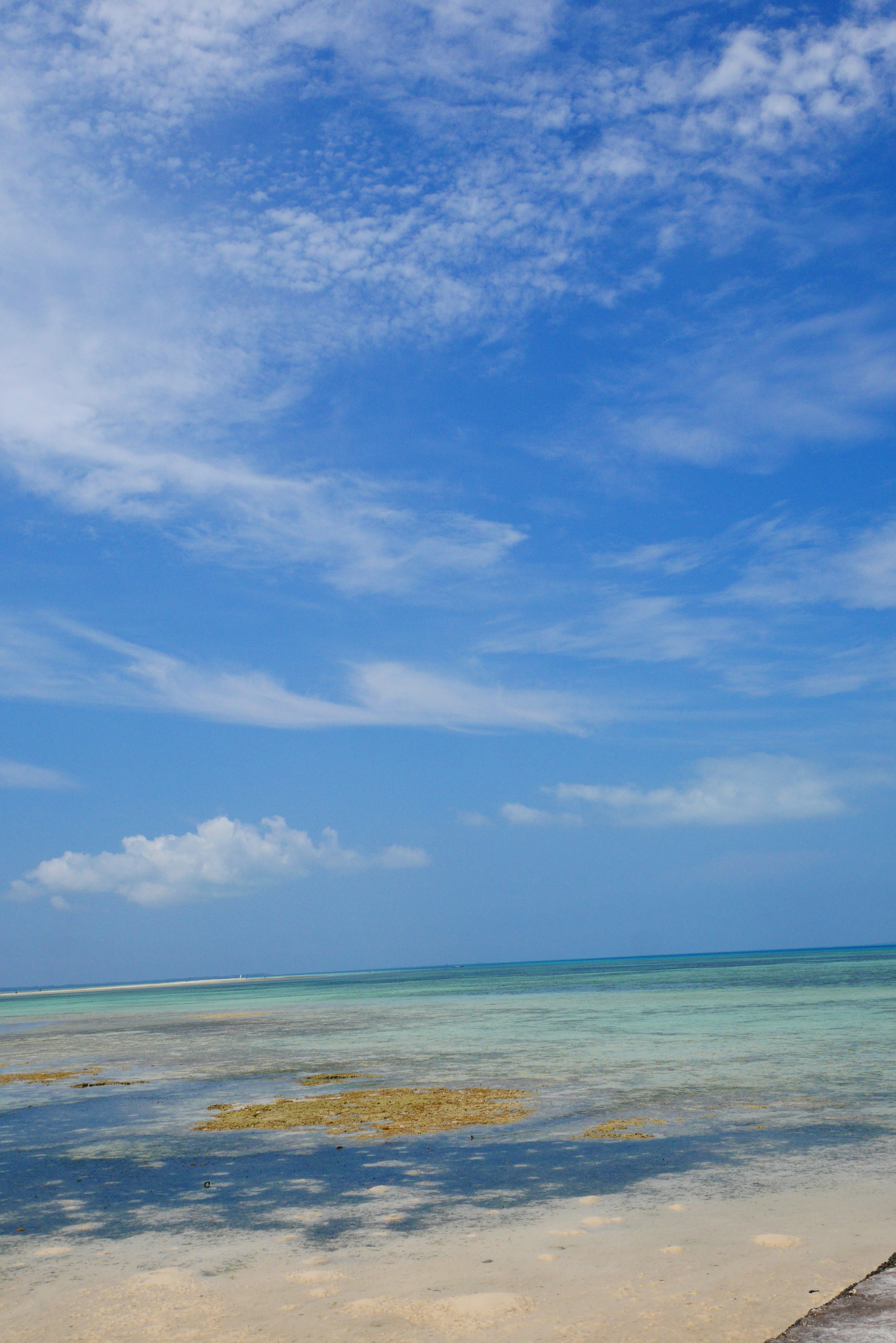 Weitläufiger blauer Ozean und Himmel mit verstreuten Wolken