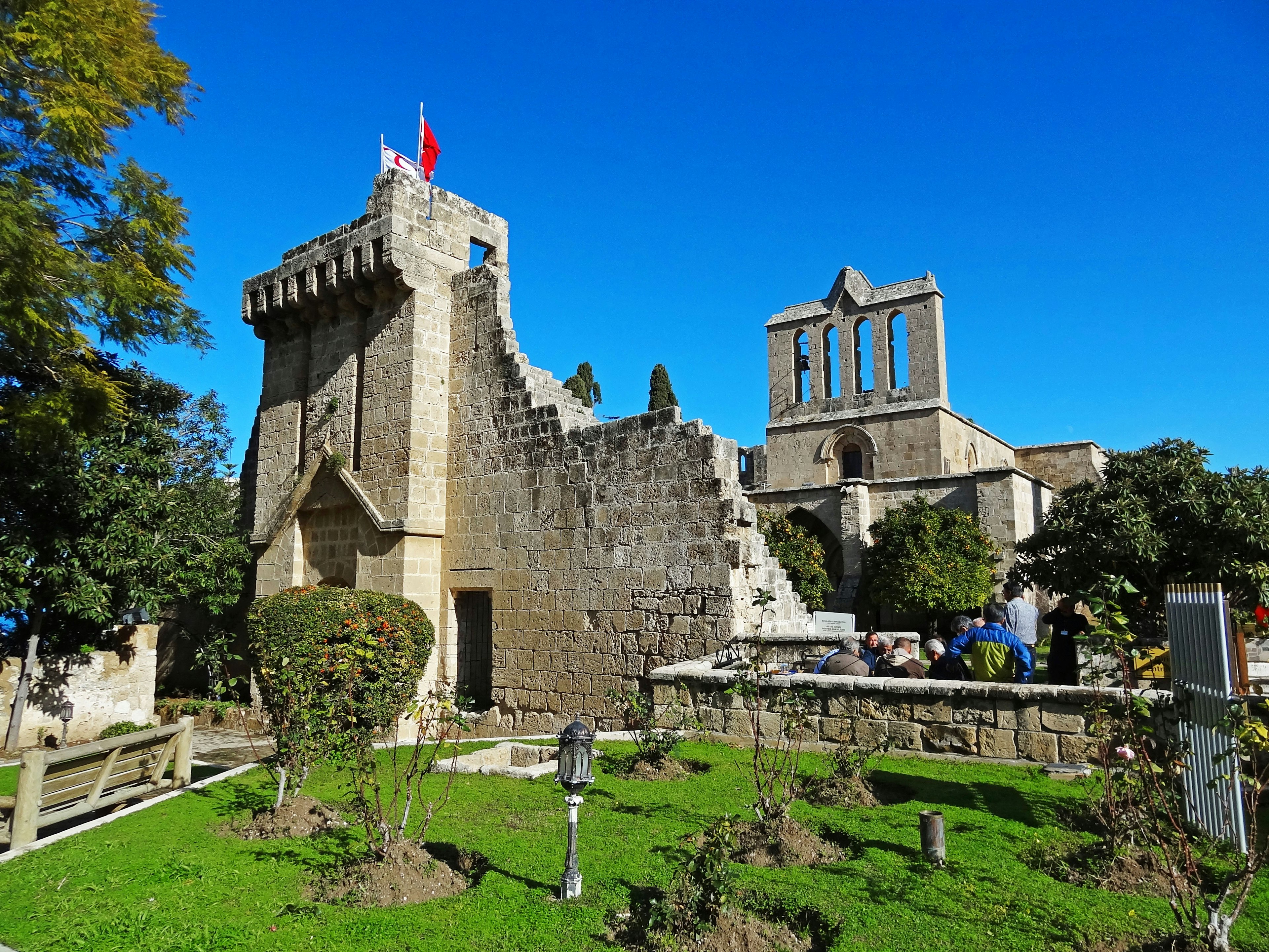 Ruines anciennes avec un jardin vert sous un ciel bleu clair