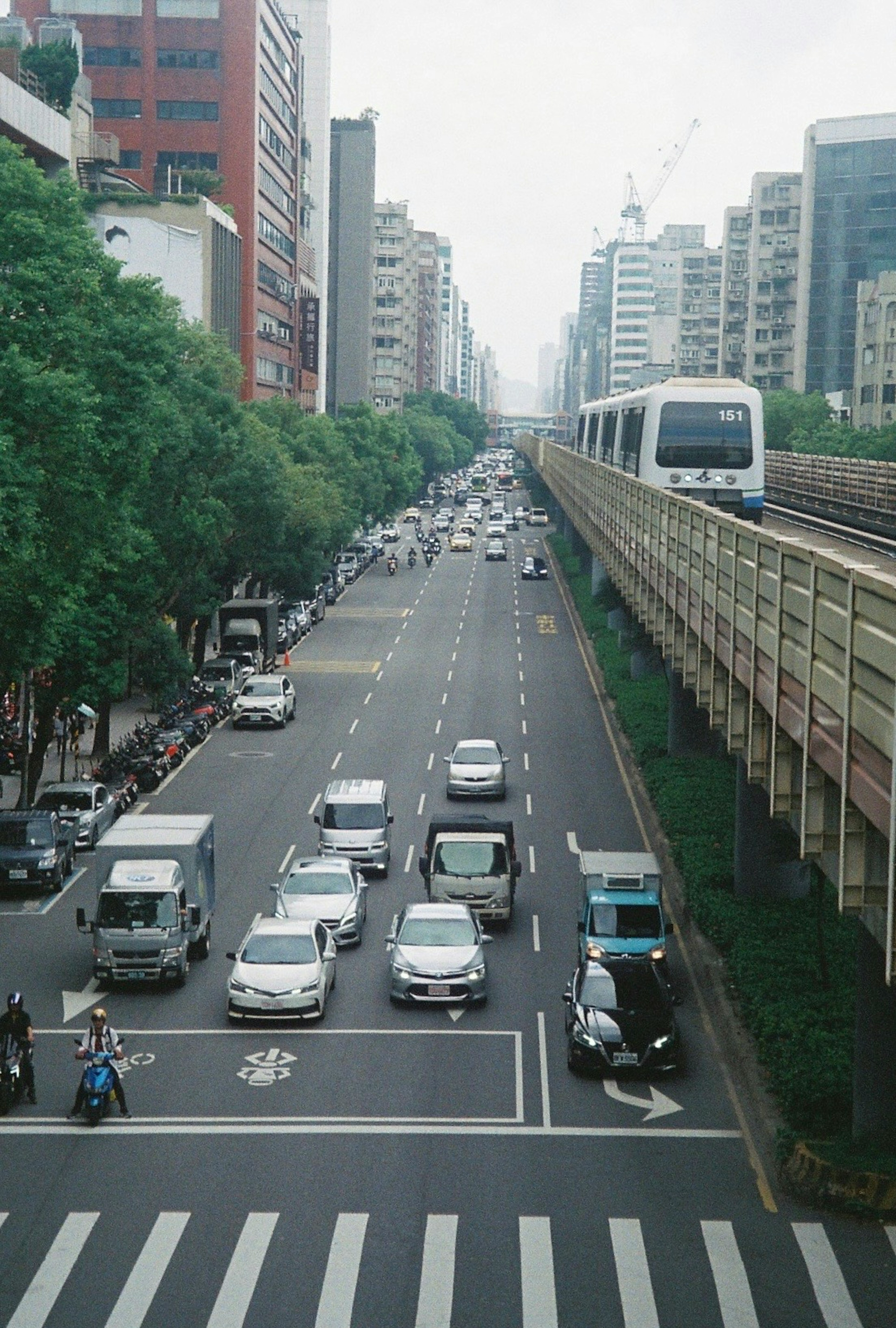 Pemandangan kota yang ramai dengan kereta api elevated dan lalu lintas padat