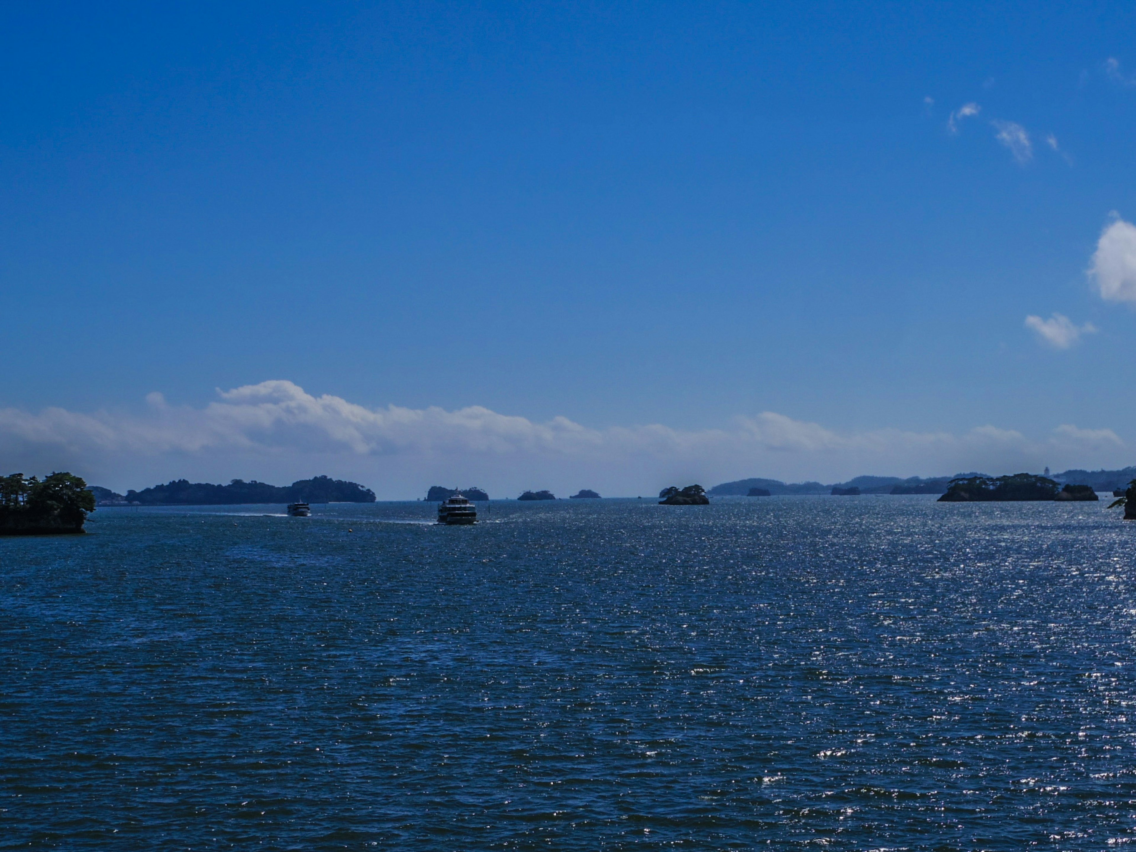 Vue panoramique d'une mer bleue avec des bateaux et de grands nuages dans le ciel