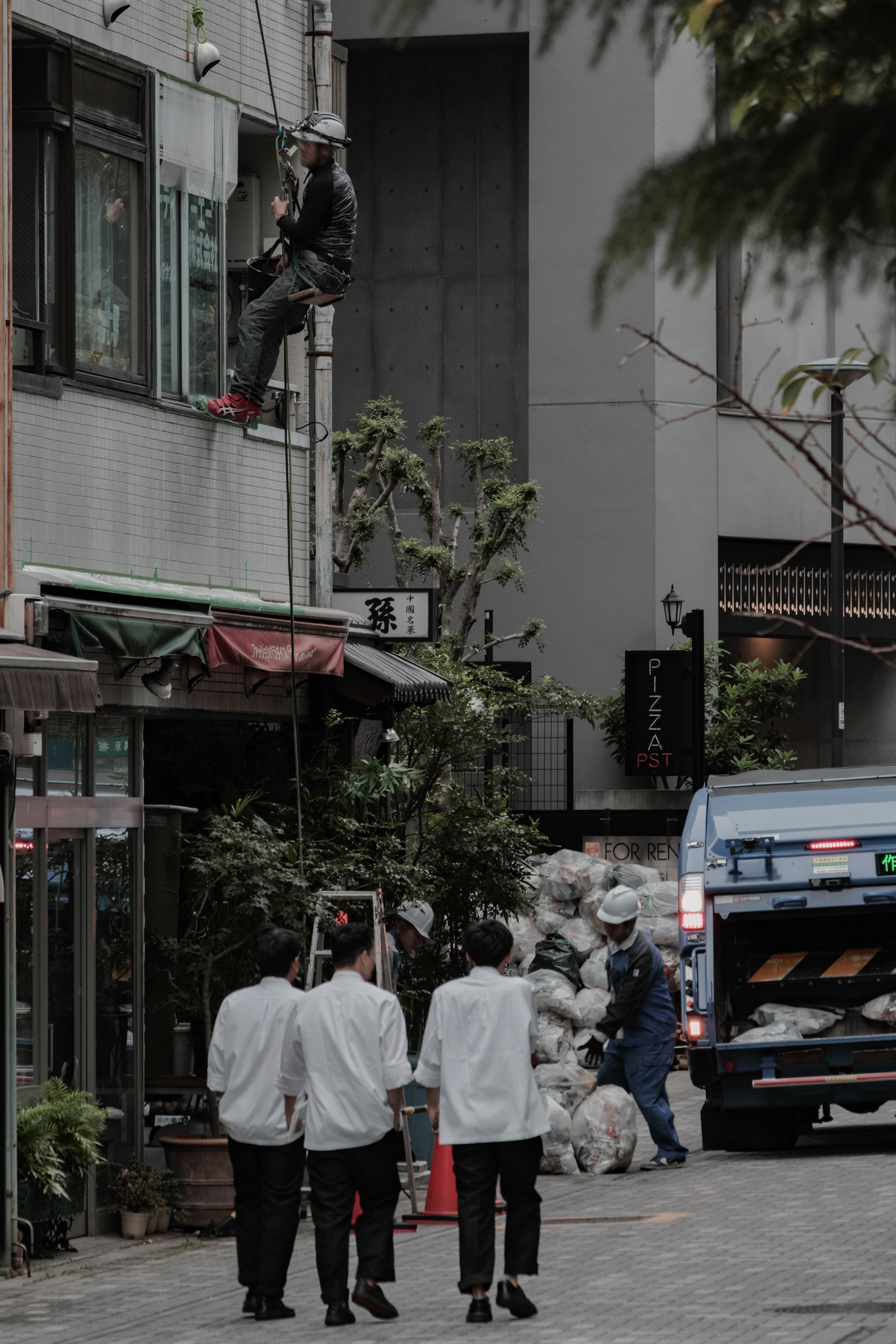 街道场景，工人在清洁窗户，西装人士走过