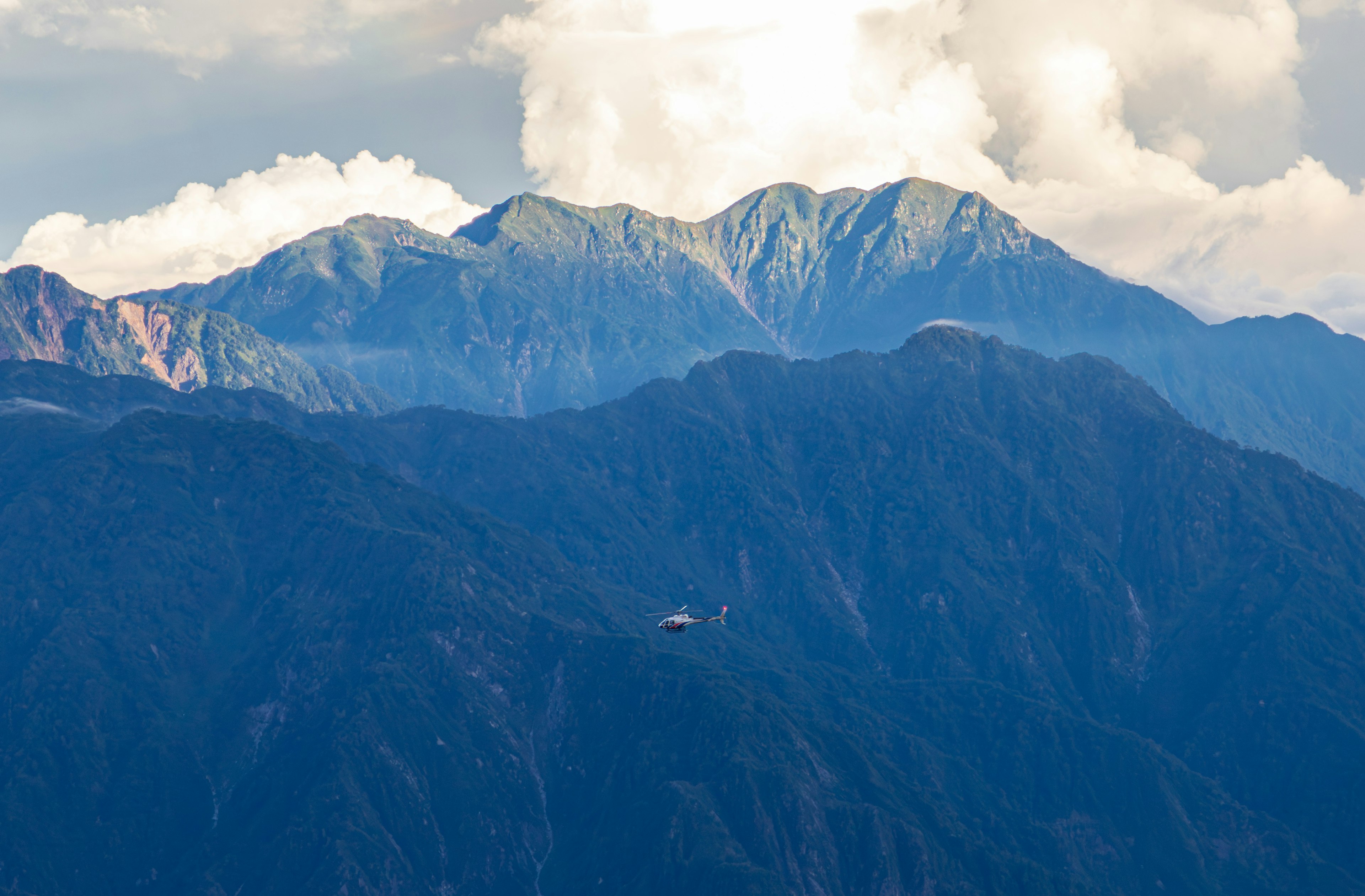 Malersiche Aussicht auf Berge und Wolken mit einem kleinen Flugzeug