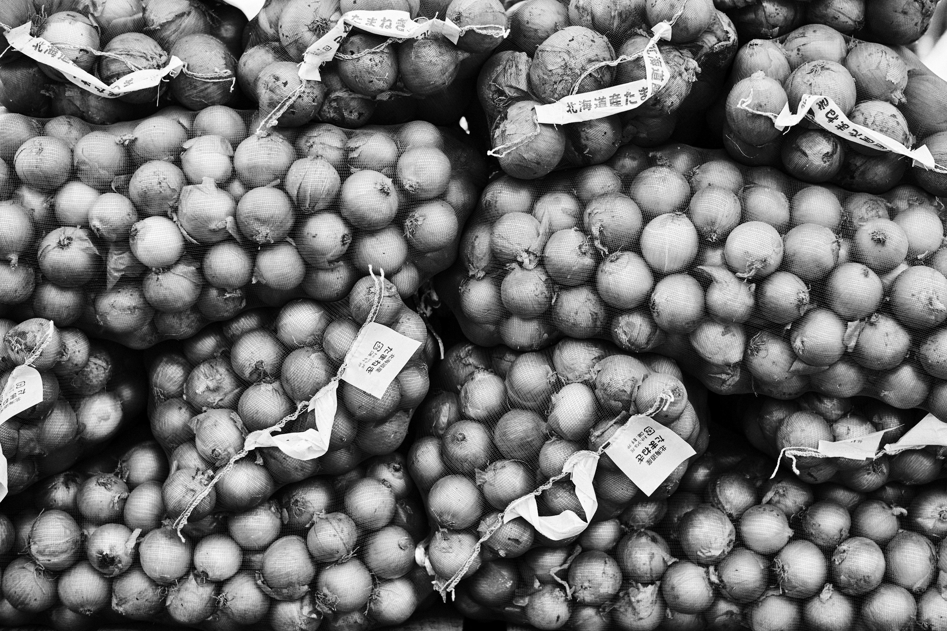 Piles of onions in black and white at a market