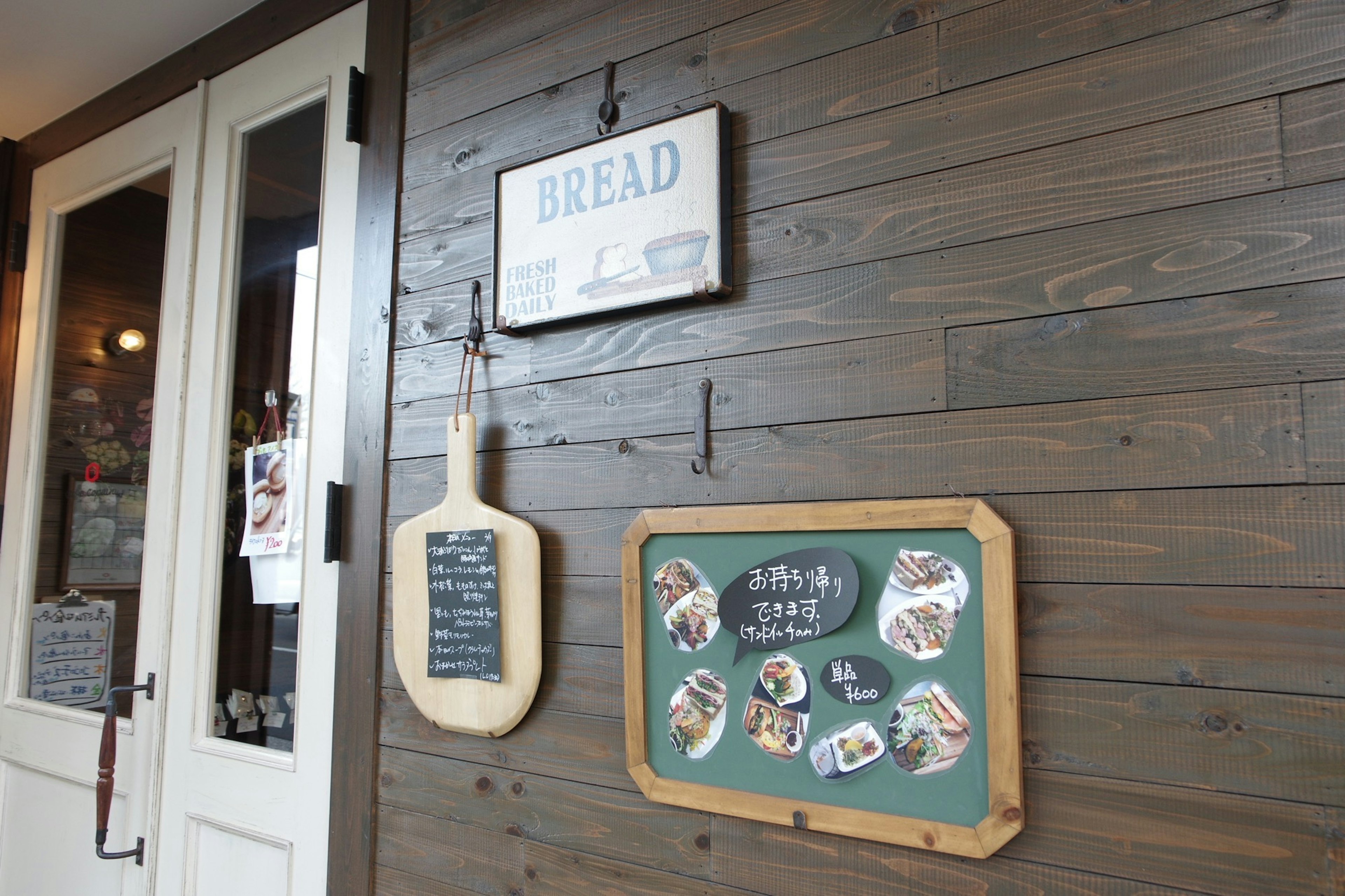 Wooden wall with hanging bread sign and menu board