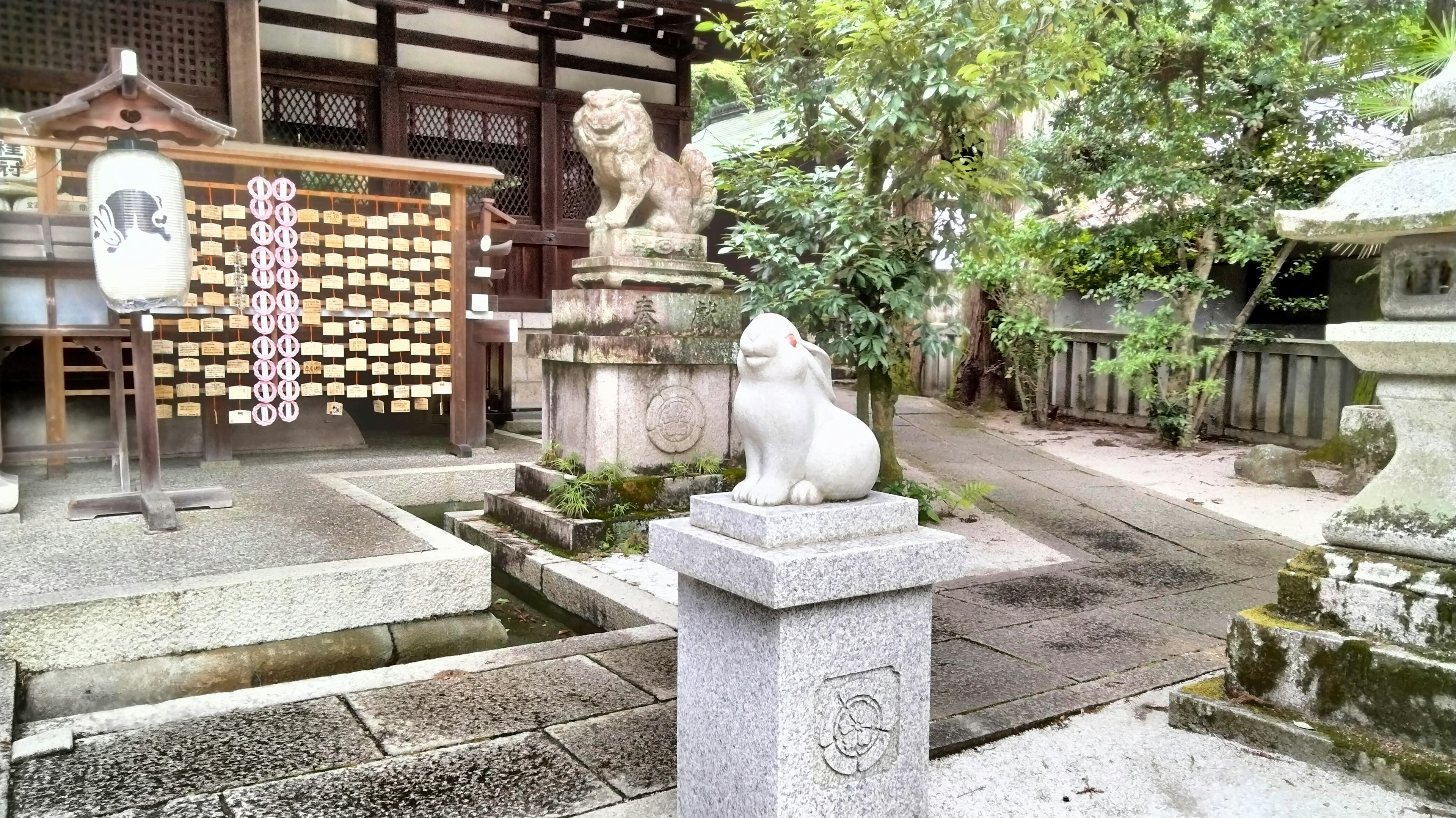 Statue en pierre devant un sanctuaire avec des gardiens lion-chien