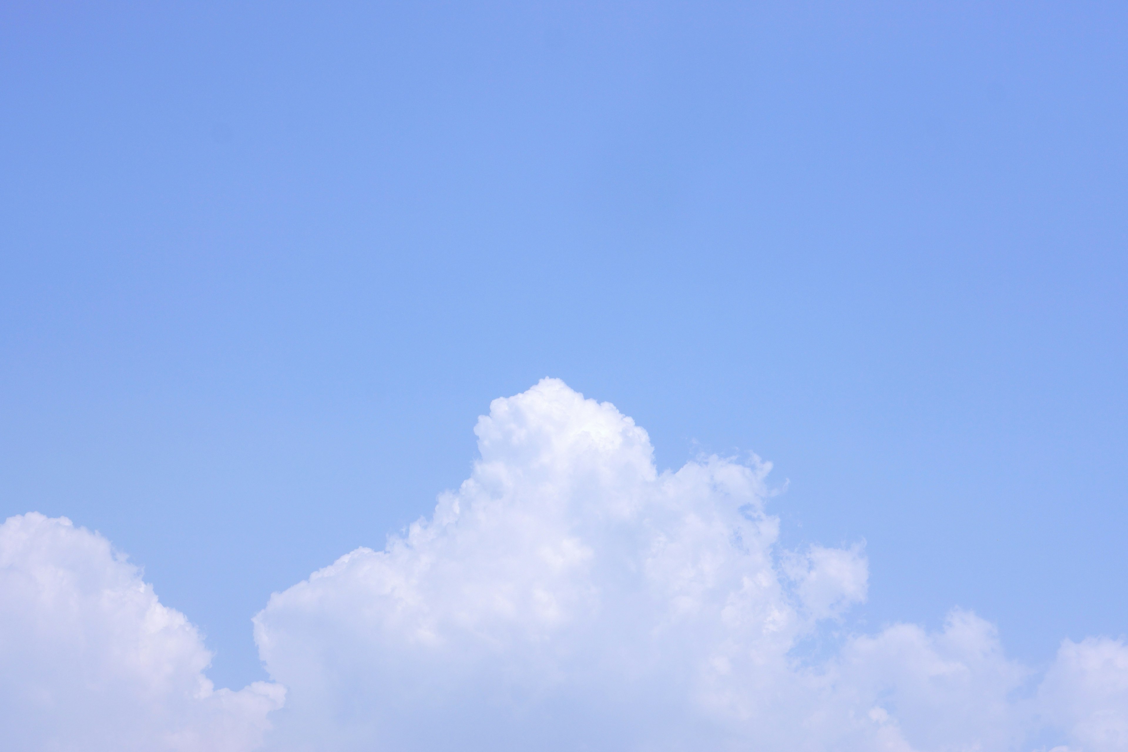 Einfache Szene mit weißen Wolken, die in einem blauen Himmel schweben