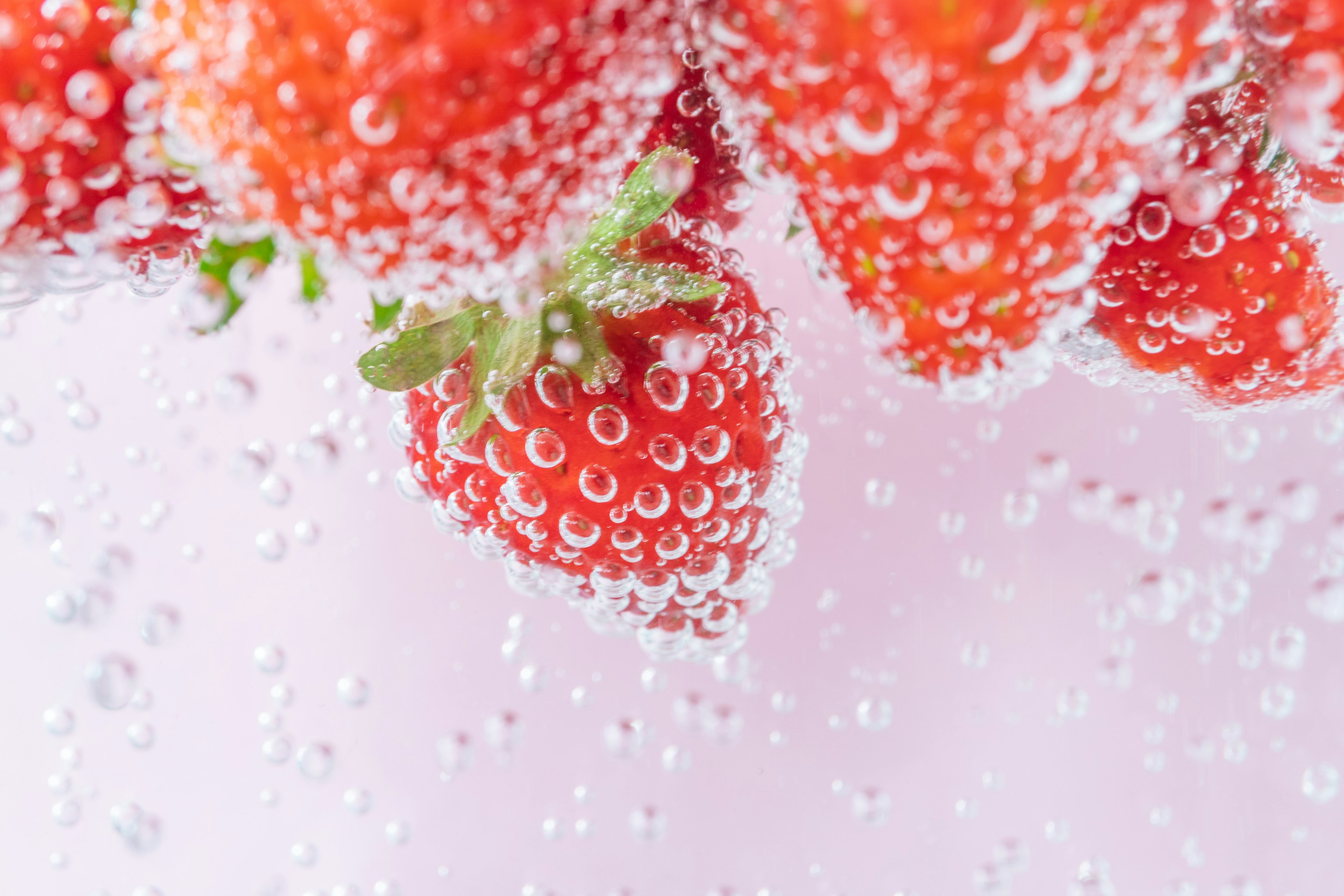 Gros plan sur des fraises fraîches immergées dans des bulles