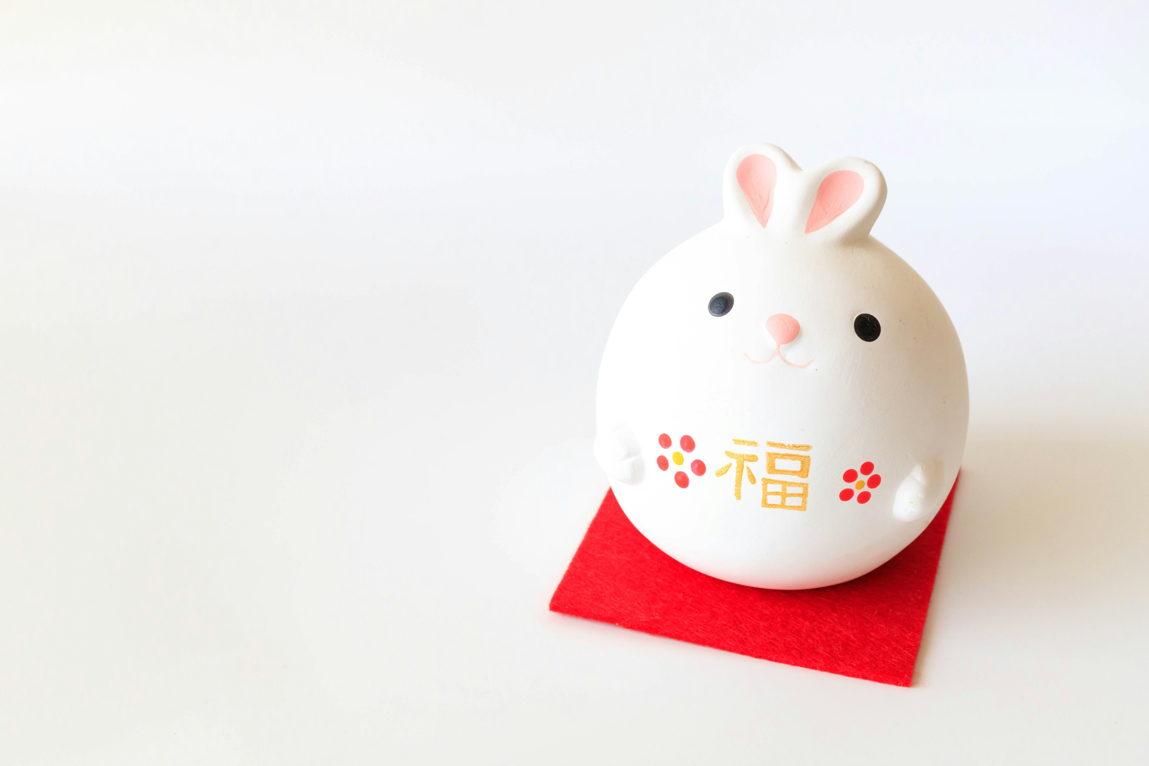 White rabbit-shaped ceramic ornament placed on a red mat