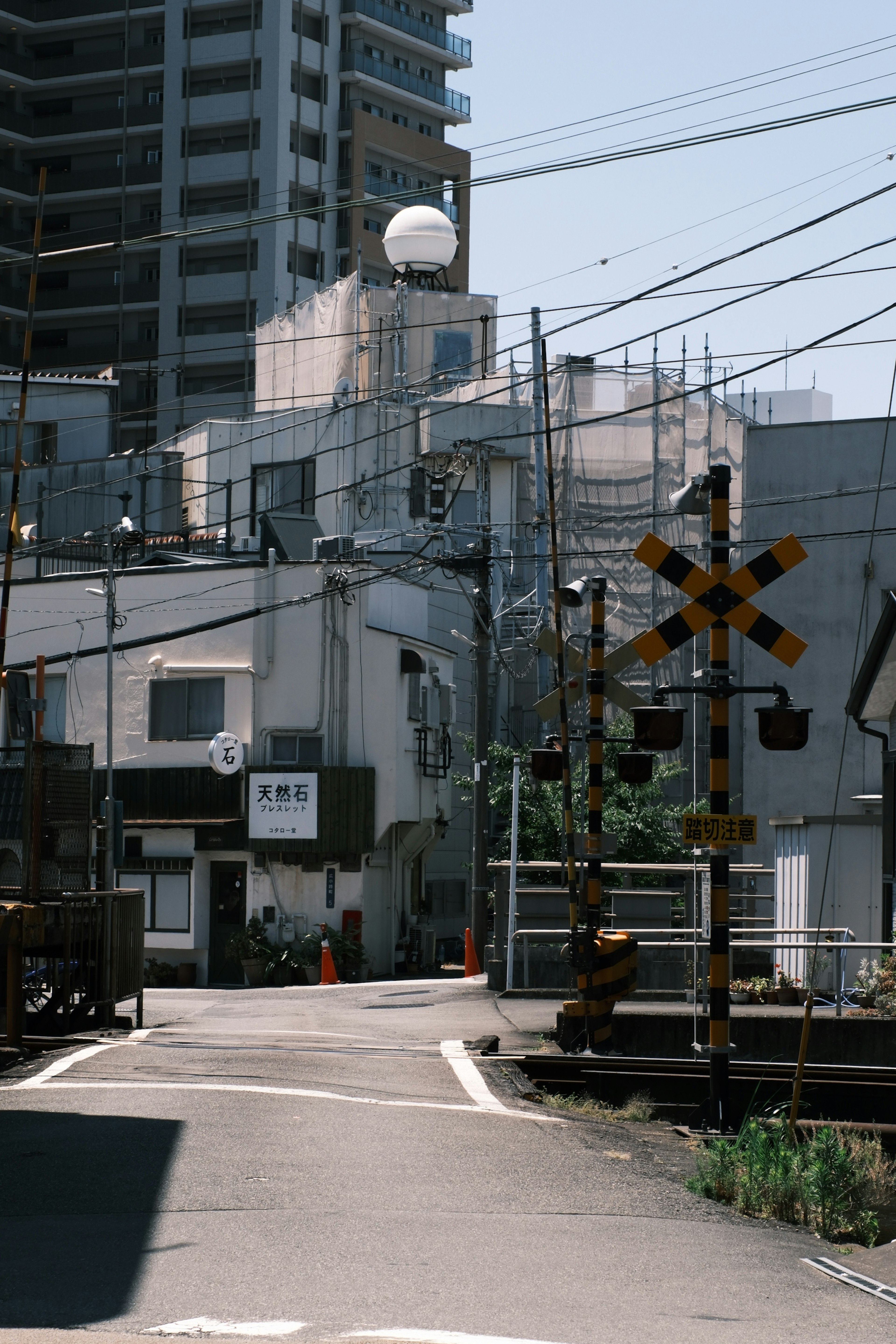 A view of a railway crossing in a residential area with a high-rise building