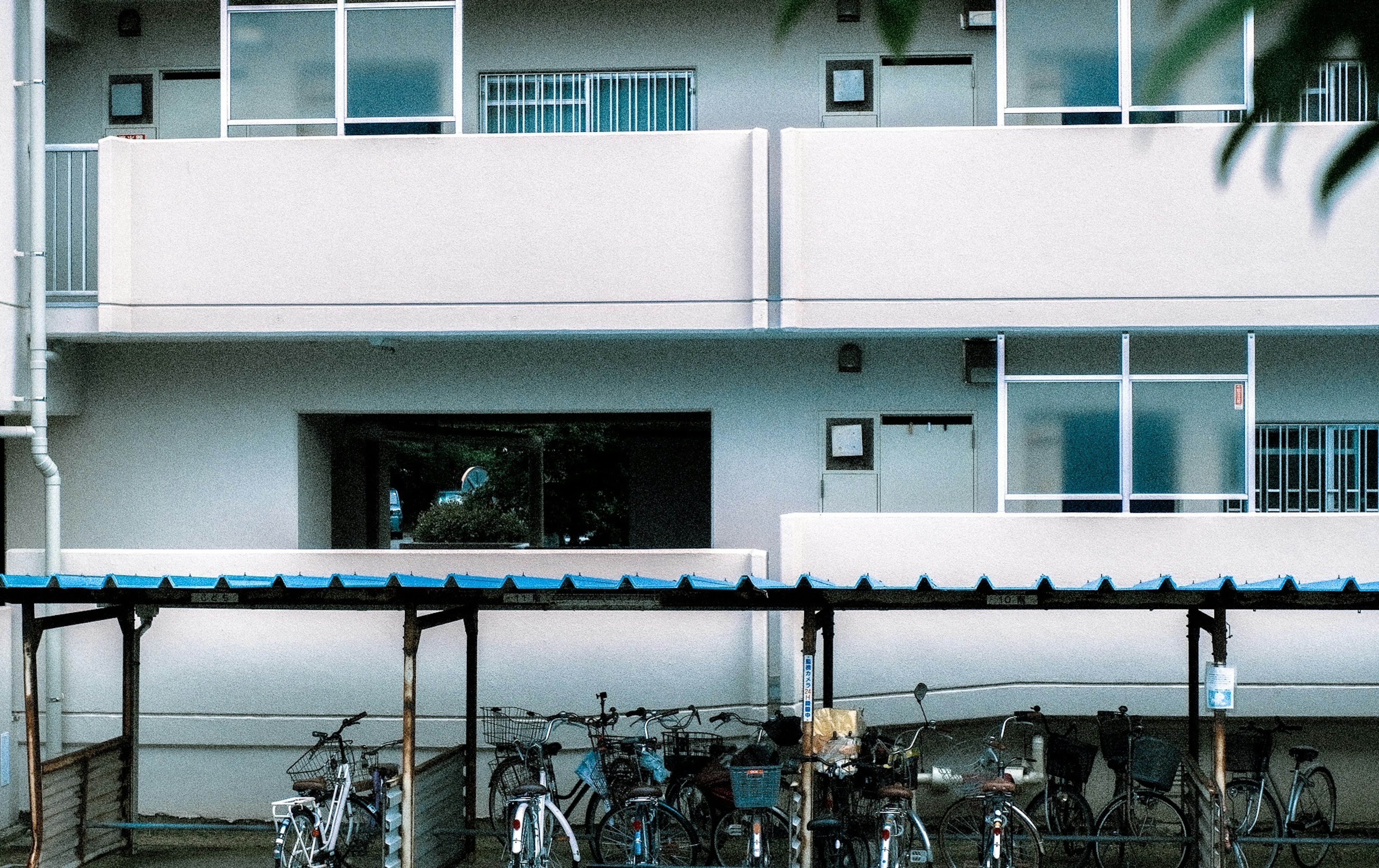 Exterior of a white apartment building with parked bicycles