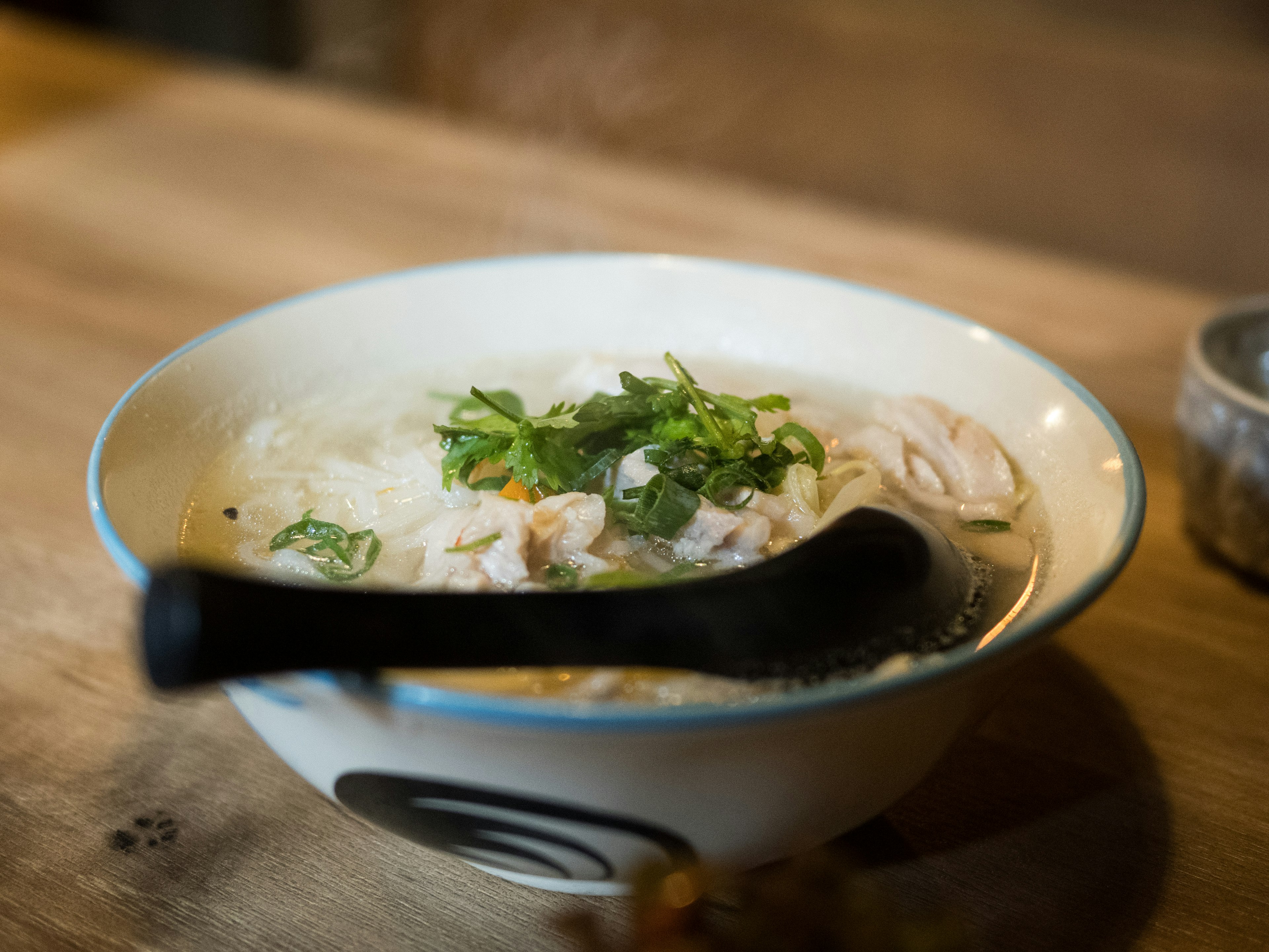 Schüssel mit Hühnersuppe und Kräutern