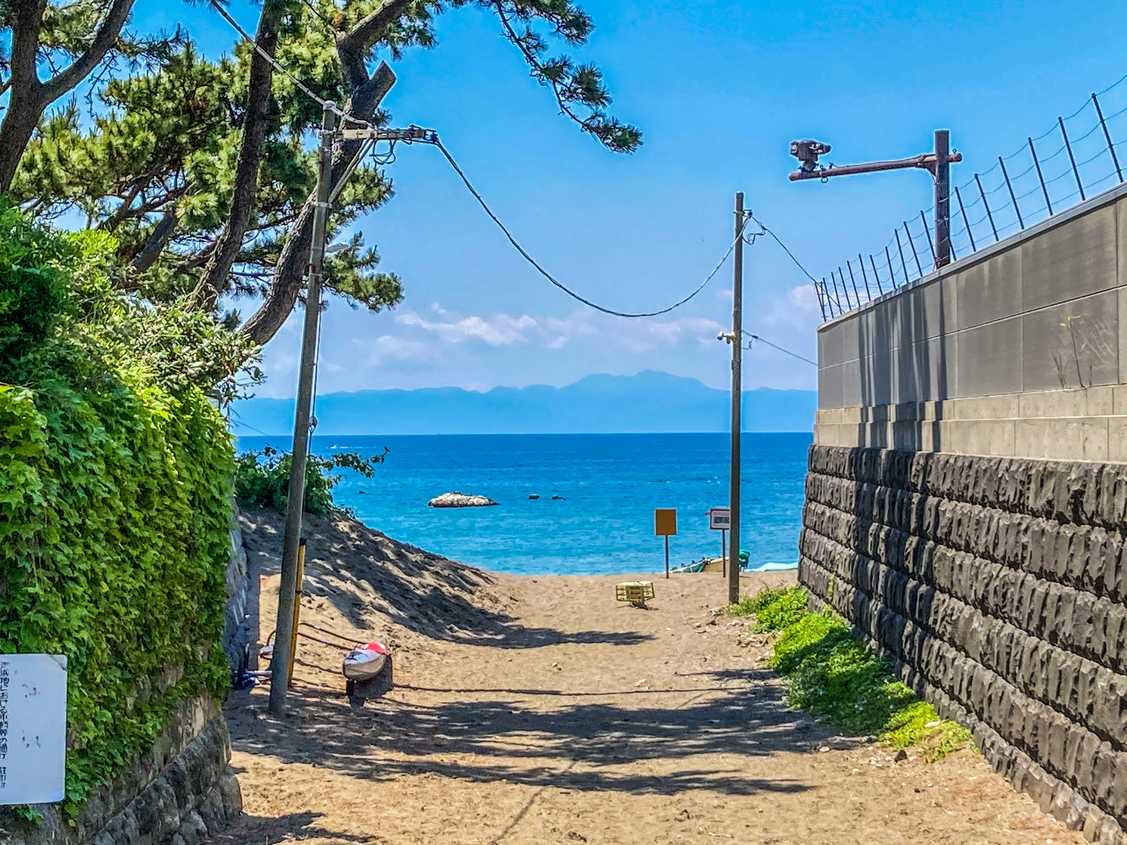 Chemin menant à une plage de sable avec mer et ciel bleus