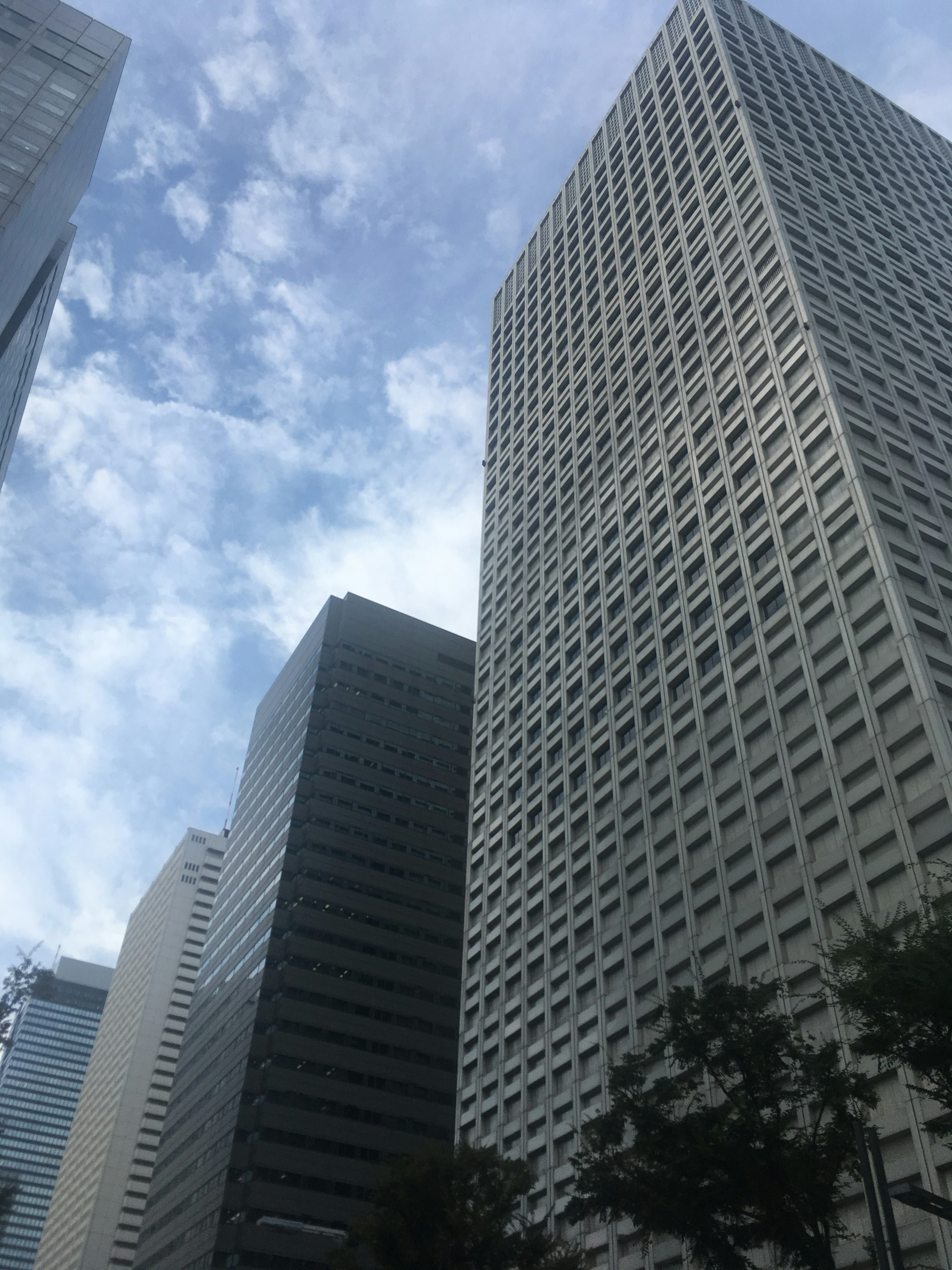 Urban landscape with towering skyscrapers against a blue sky and clouds