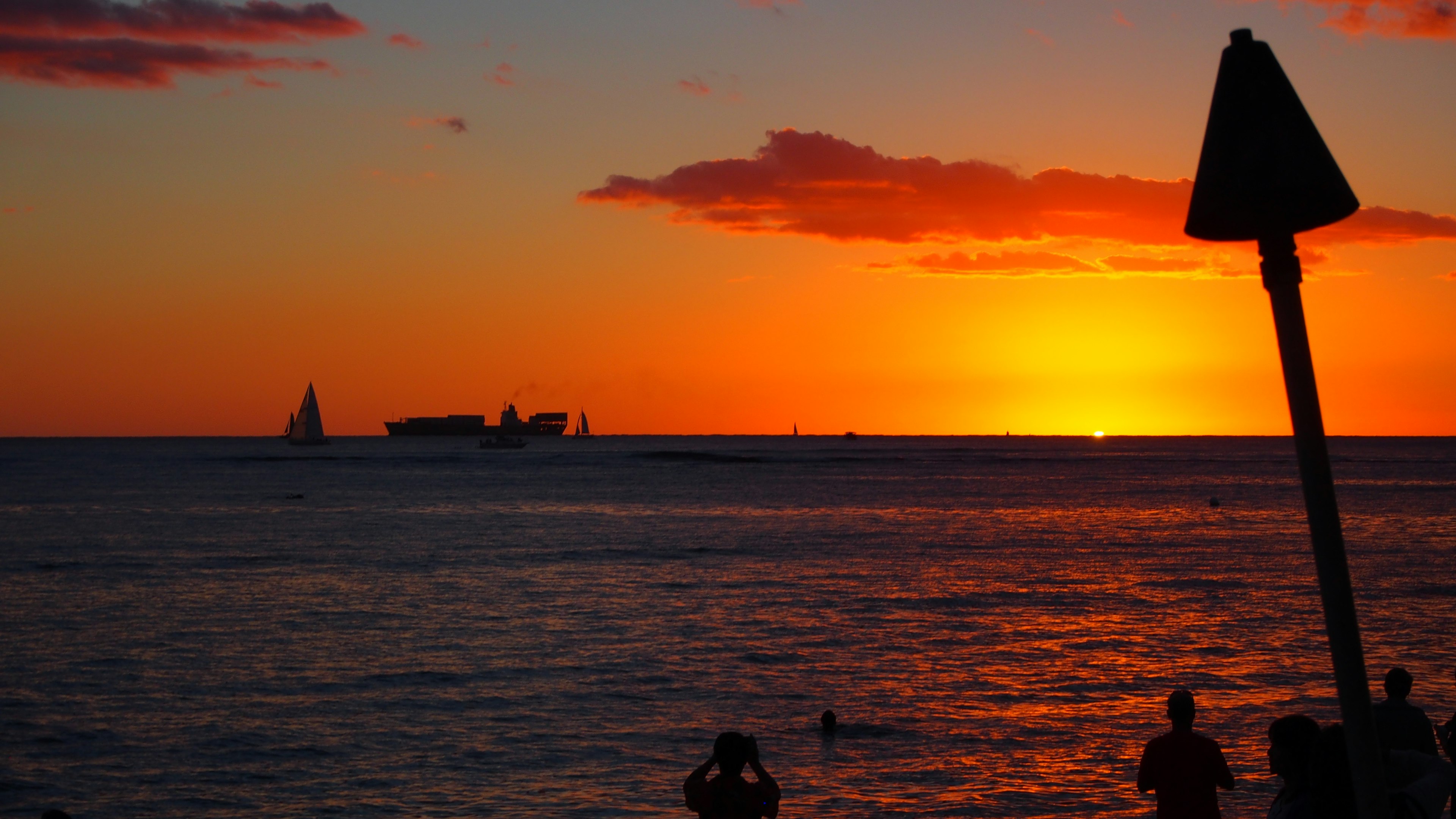 Schöner Sonnenuntergang über dem Ozean mit silhouettierten Menschen