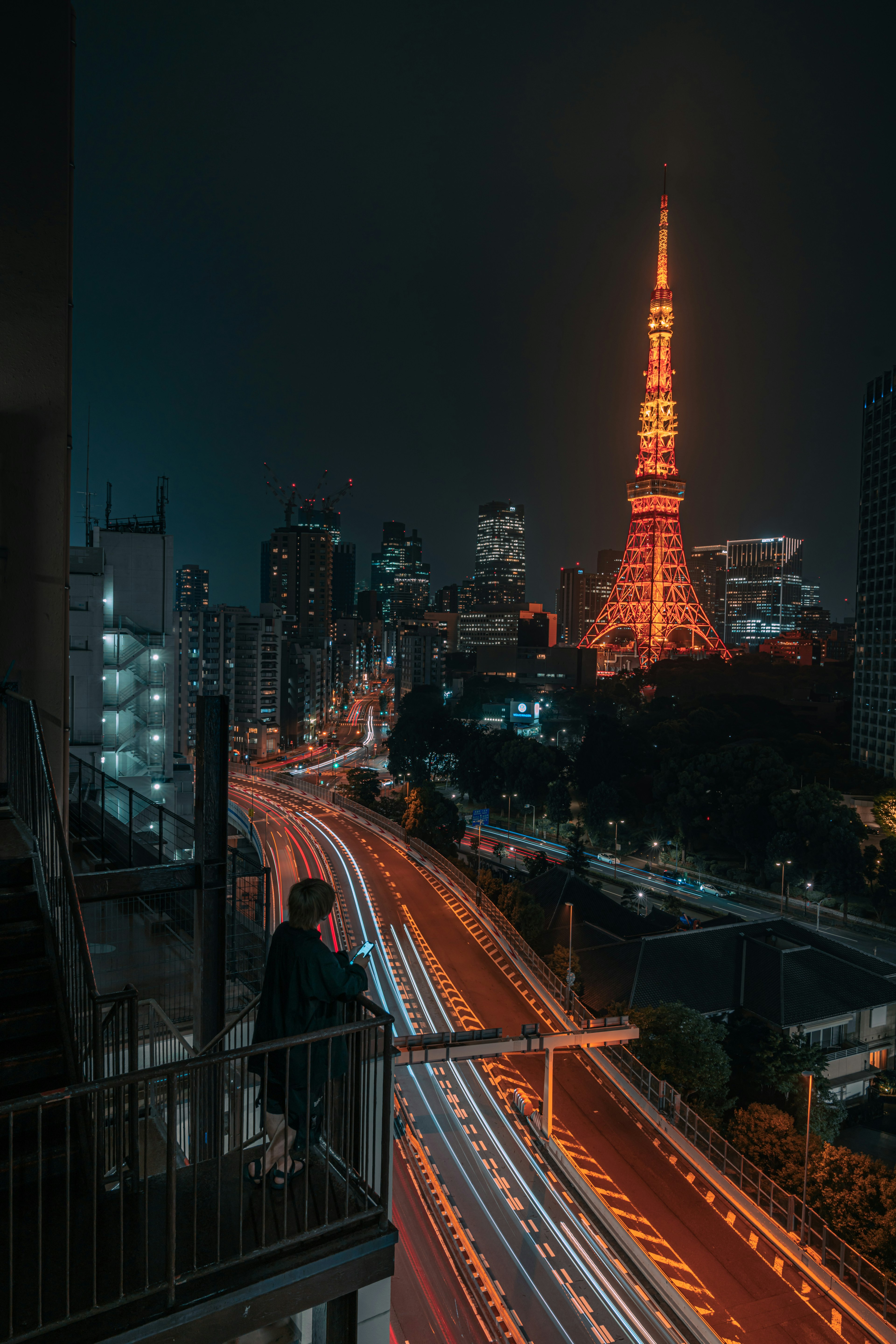 東京タワーが夜に輝く都市の景色と流れる車の光