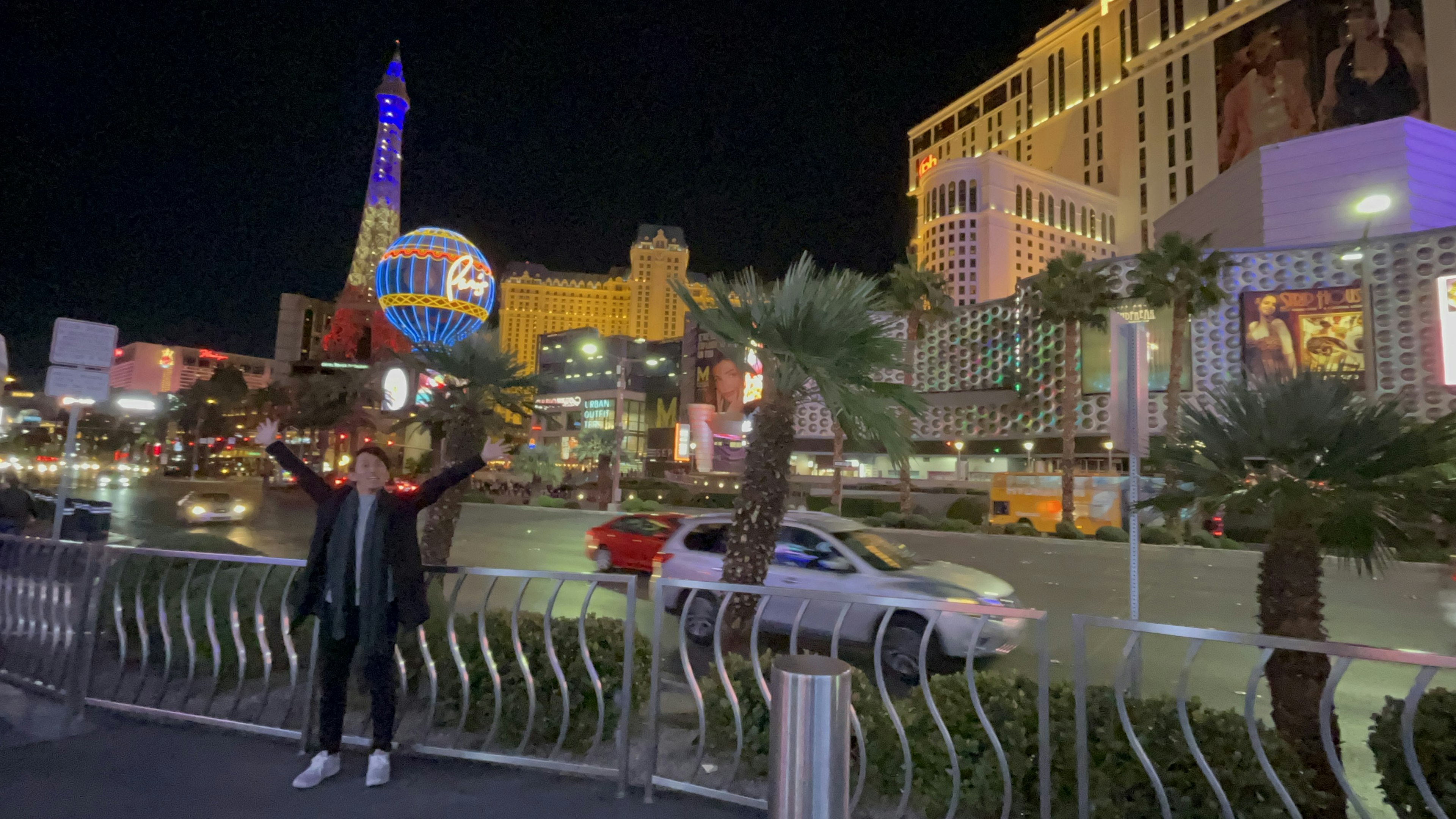 Người với tay giơ lên trước cuộc sống về đêm sôi động của Las Vegas và đèn neon