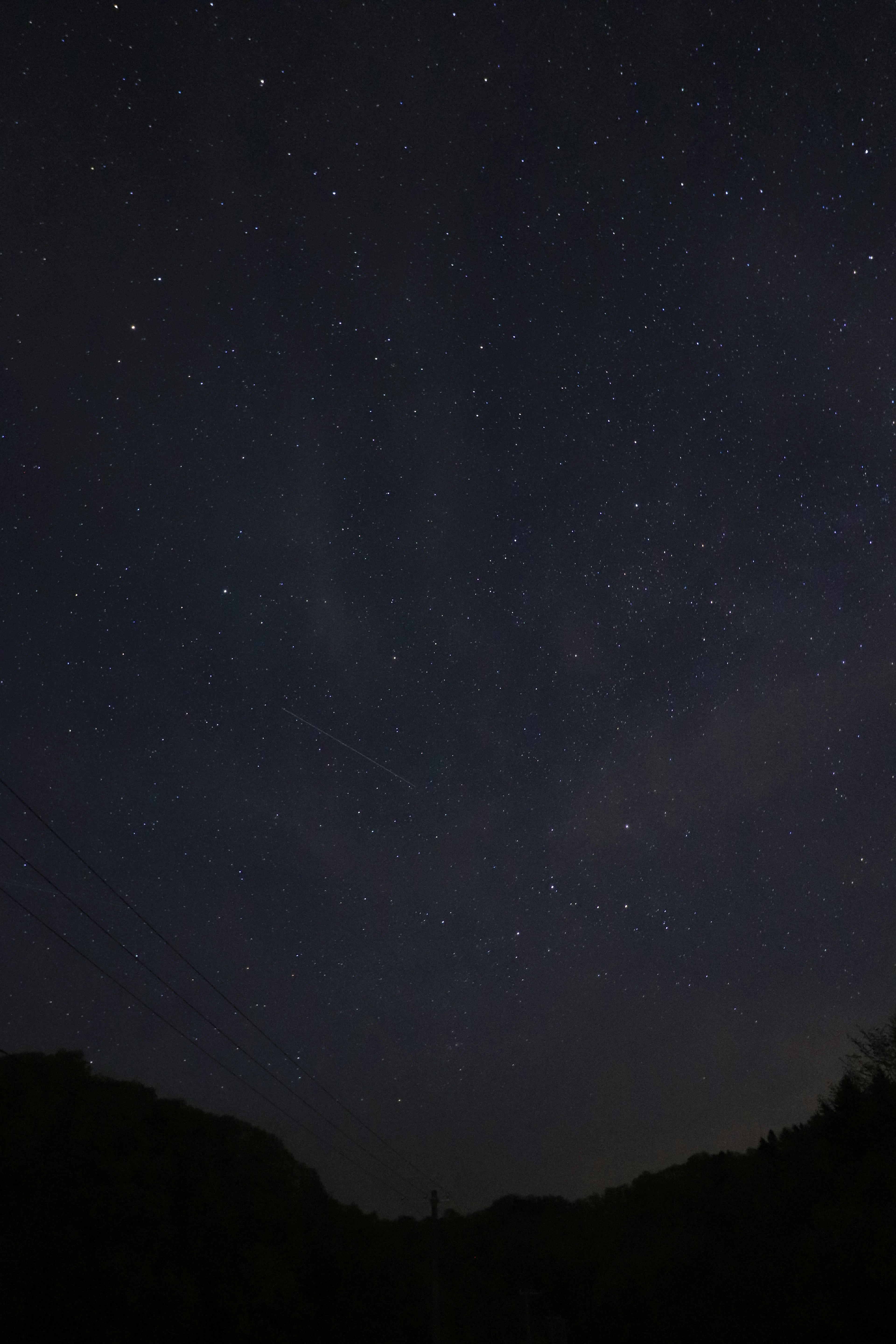 Foto de un cielo nocturno estrellado con siluetas de montañas