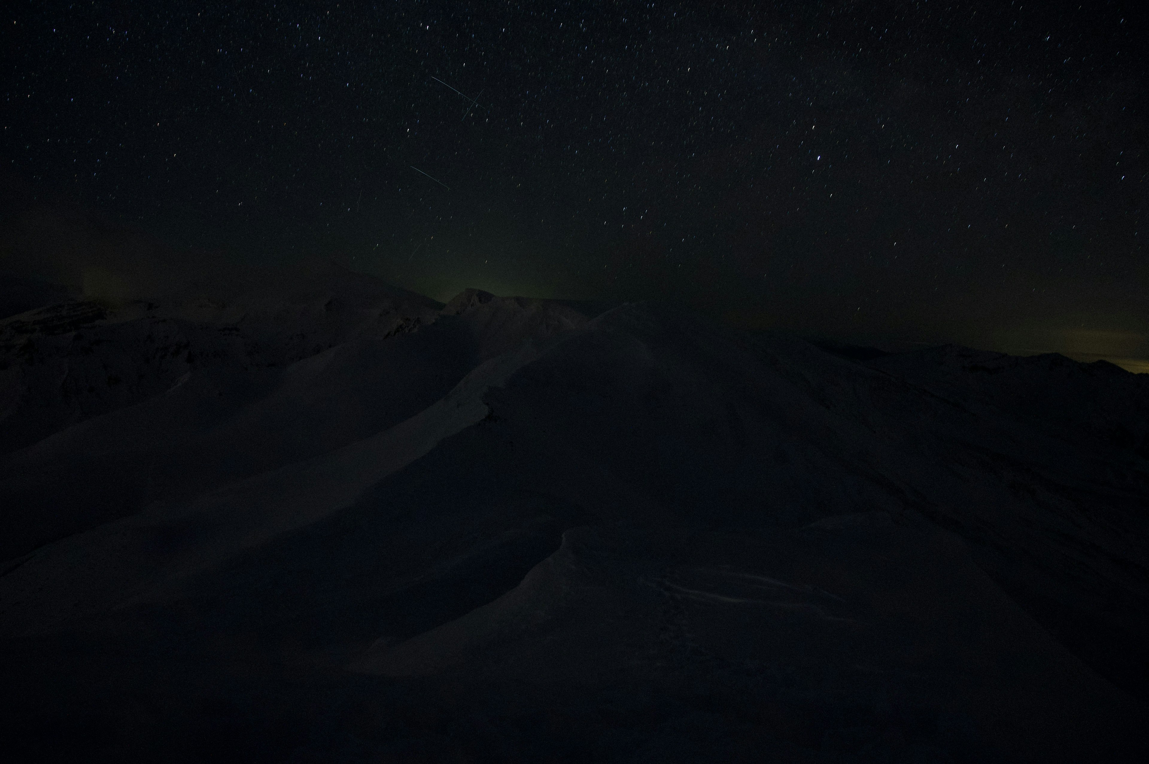 夜空に輝く星々と雪に覆われた山の風景