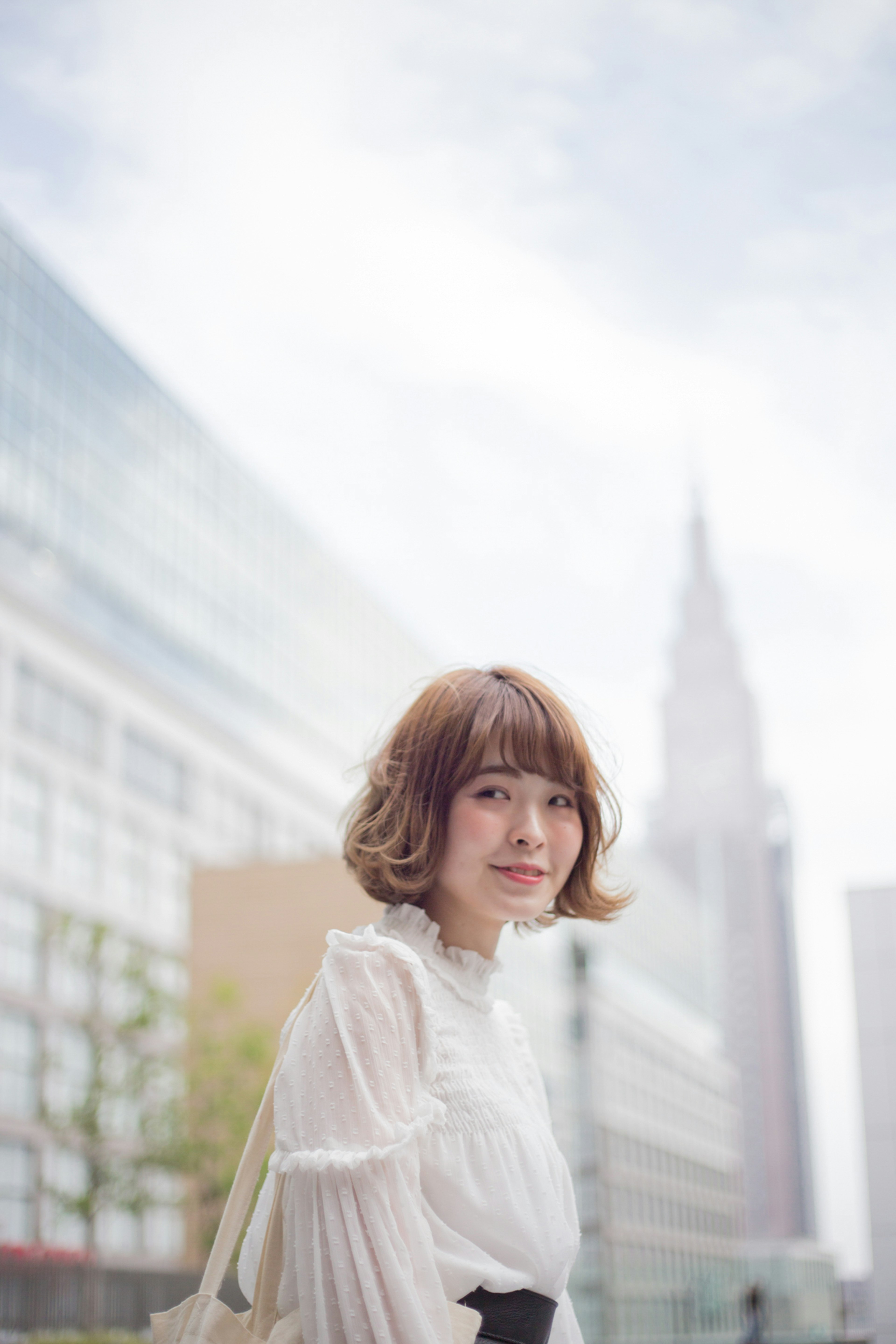 Young woman smiling in an urban setting with skyscrapers in the background