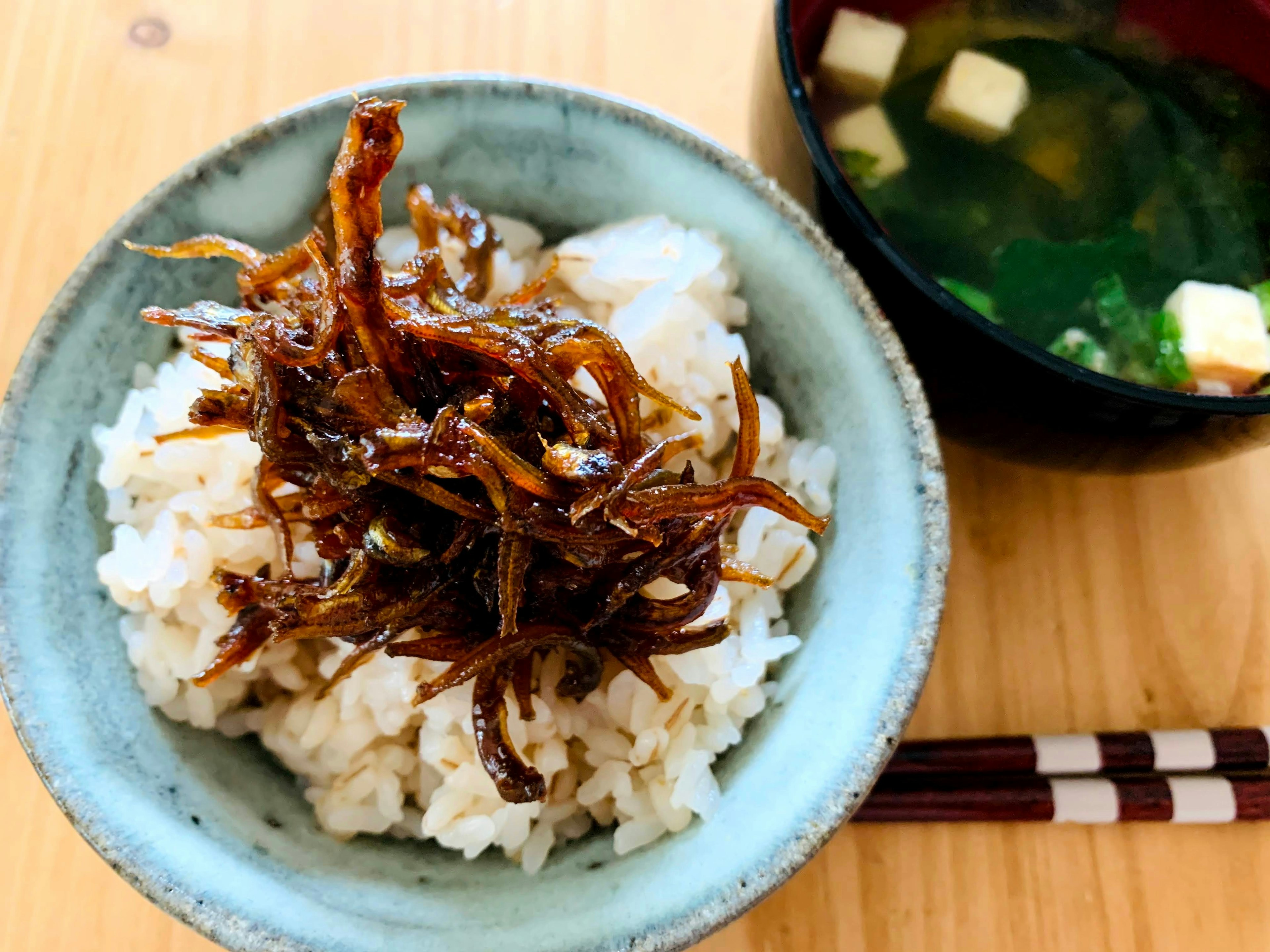 A Japanese dish with rice topped with tsukudani and a bowl of miso soup