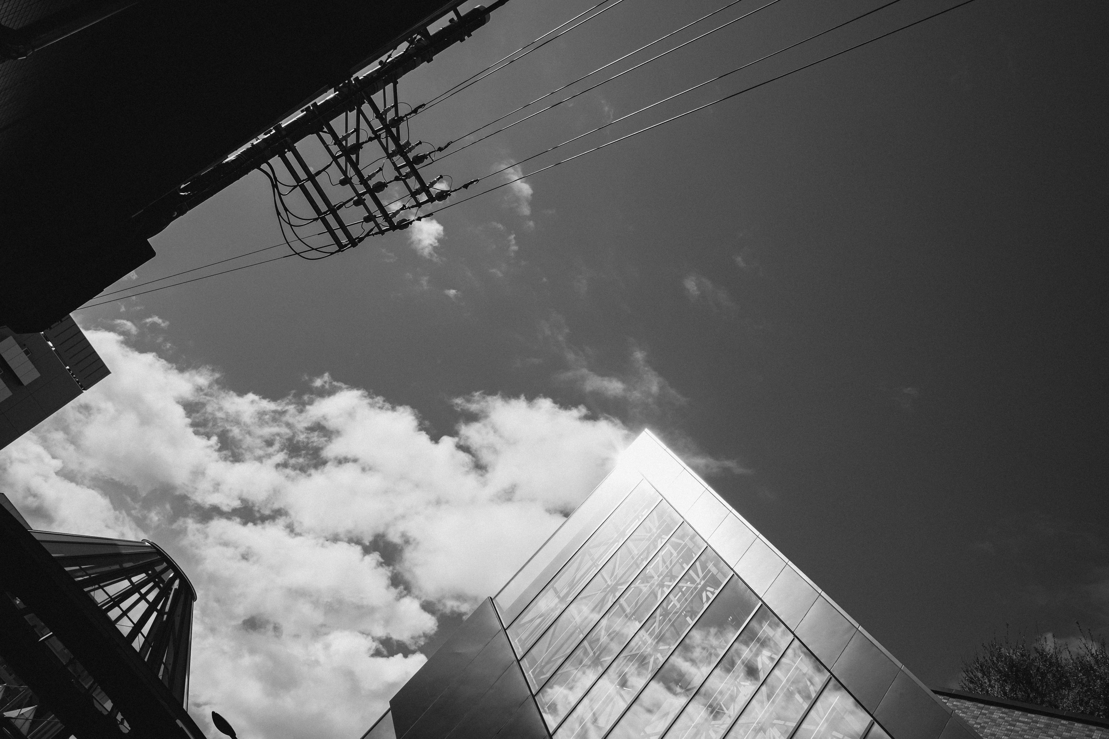 View of a skyscraper from below with clouds in the sky