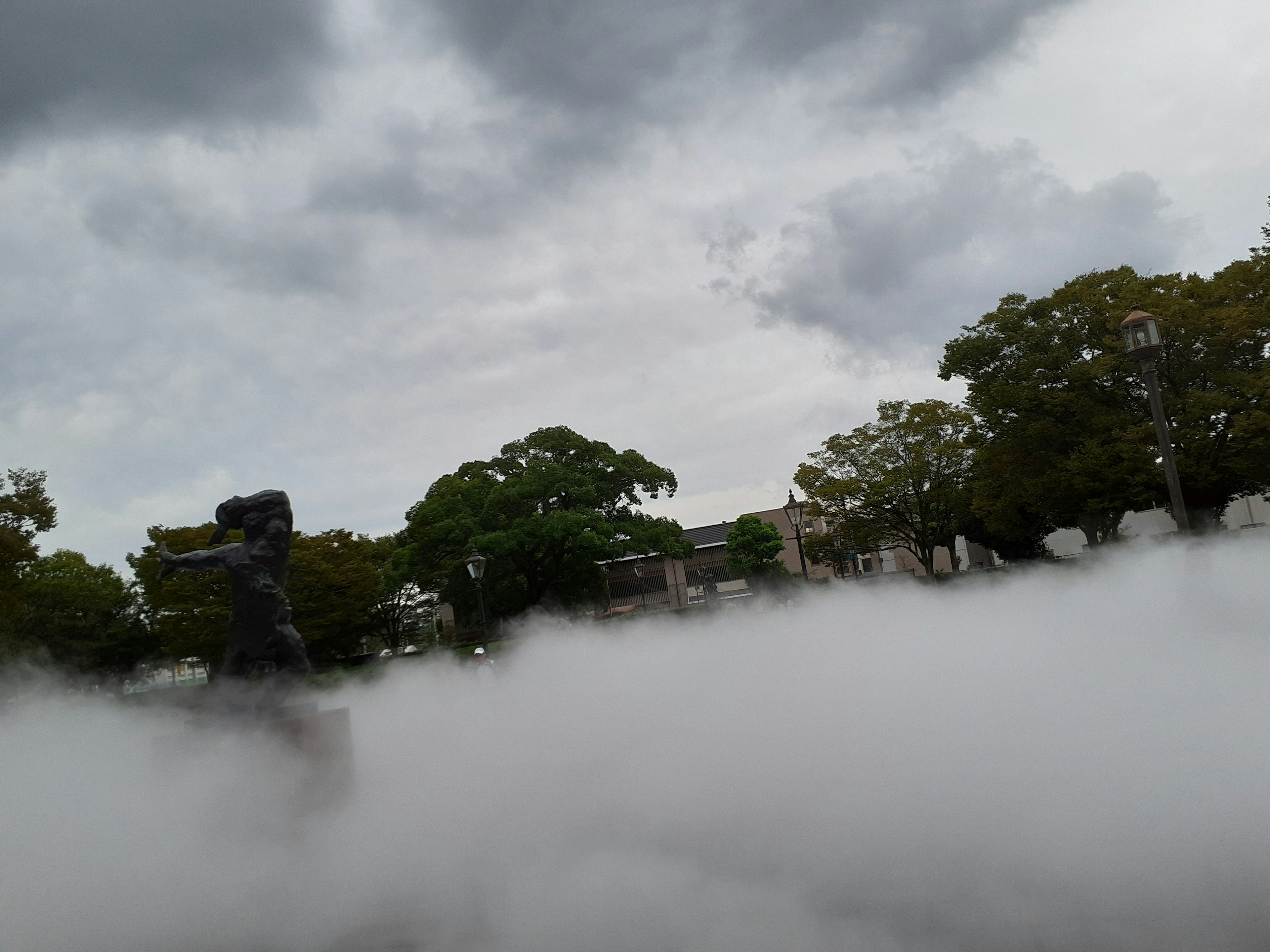 Scène de parc enveloppée de brouillard avec des silhouettes d'arbres