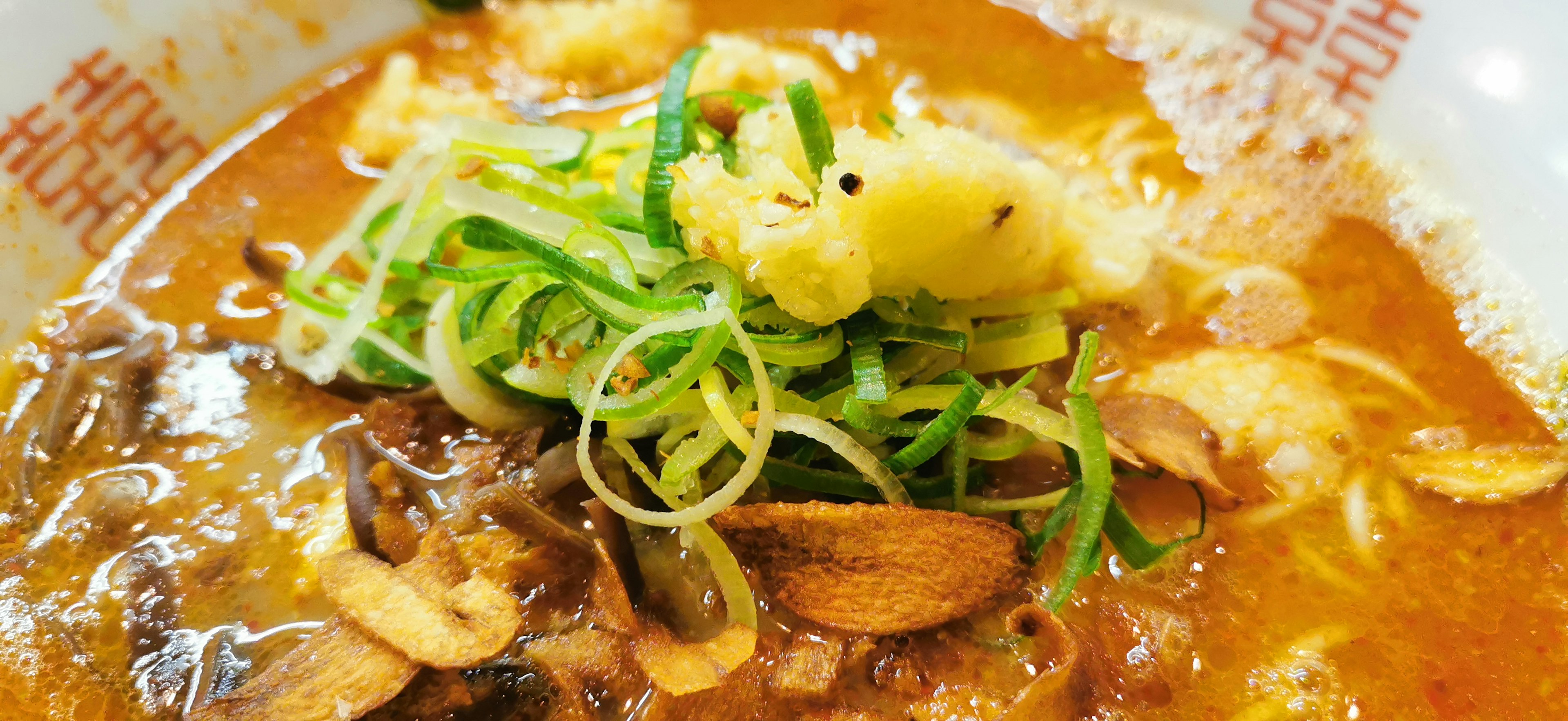 Ramen delicioso cubierto con cebollas verdes y jengibre