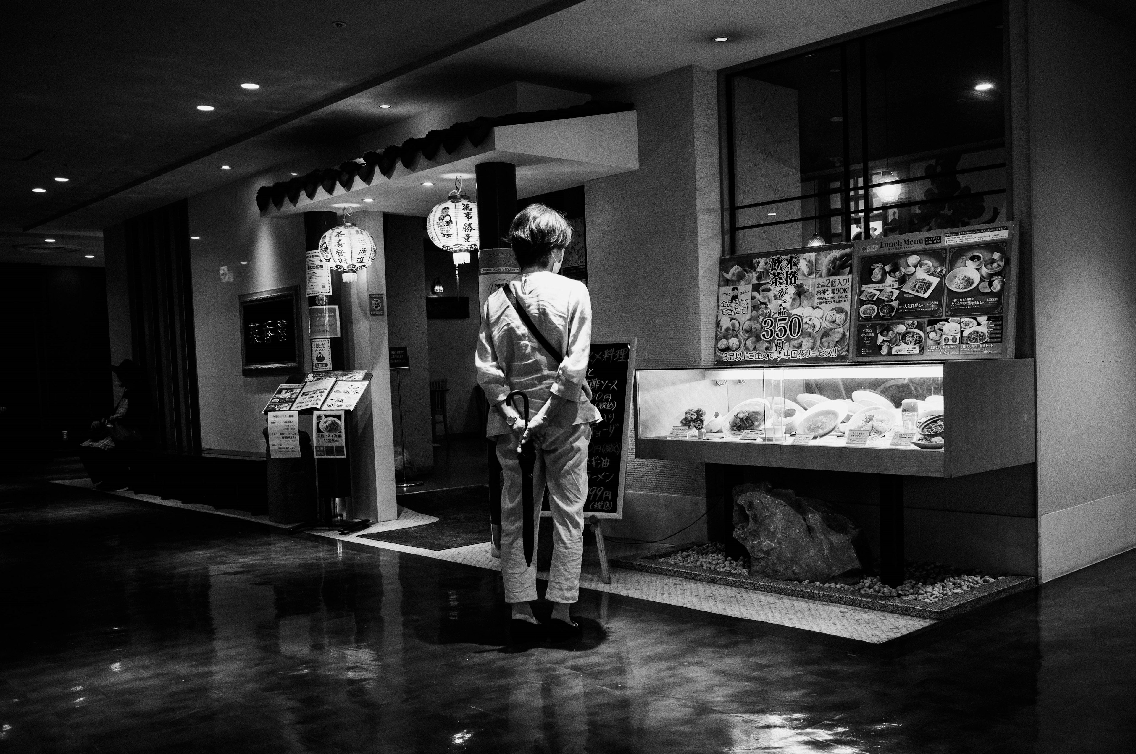 Un uomo che osserva un menu in un corridoio poco illuminato