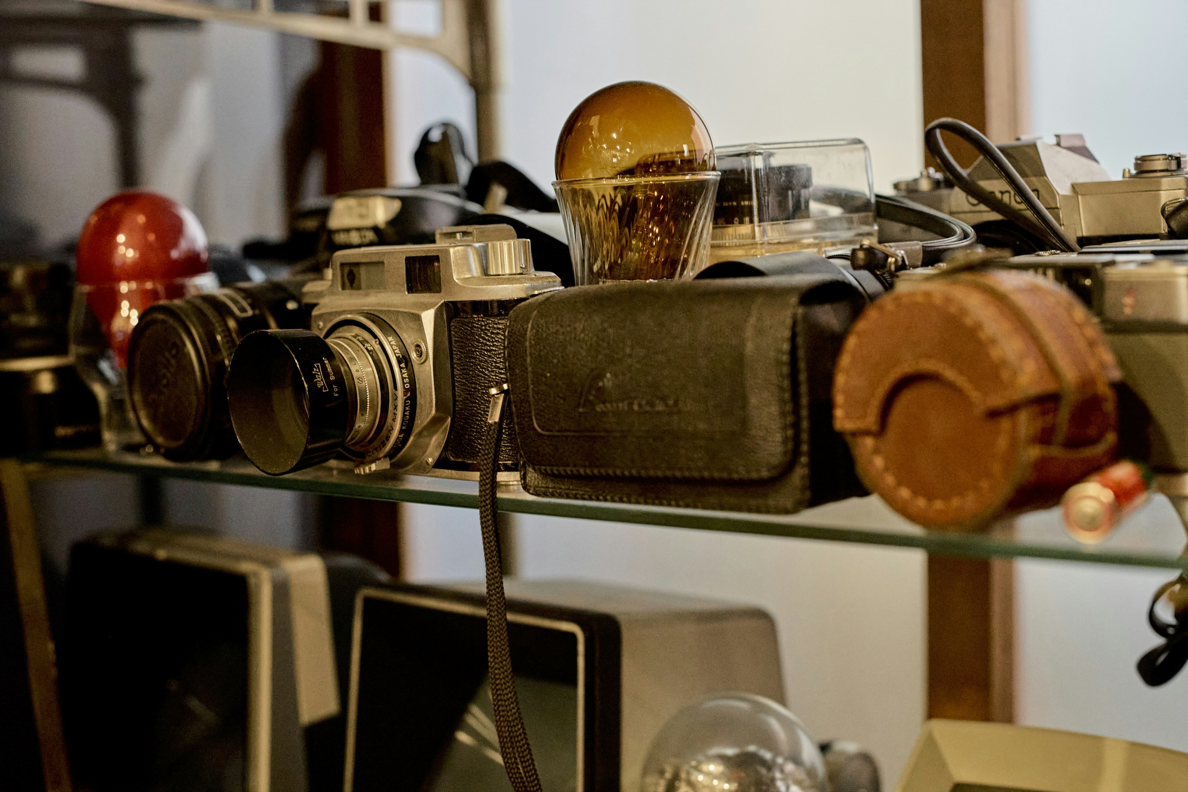 A collection of vintage cameras and retro items displayed on a shelf