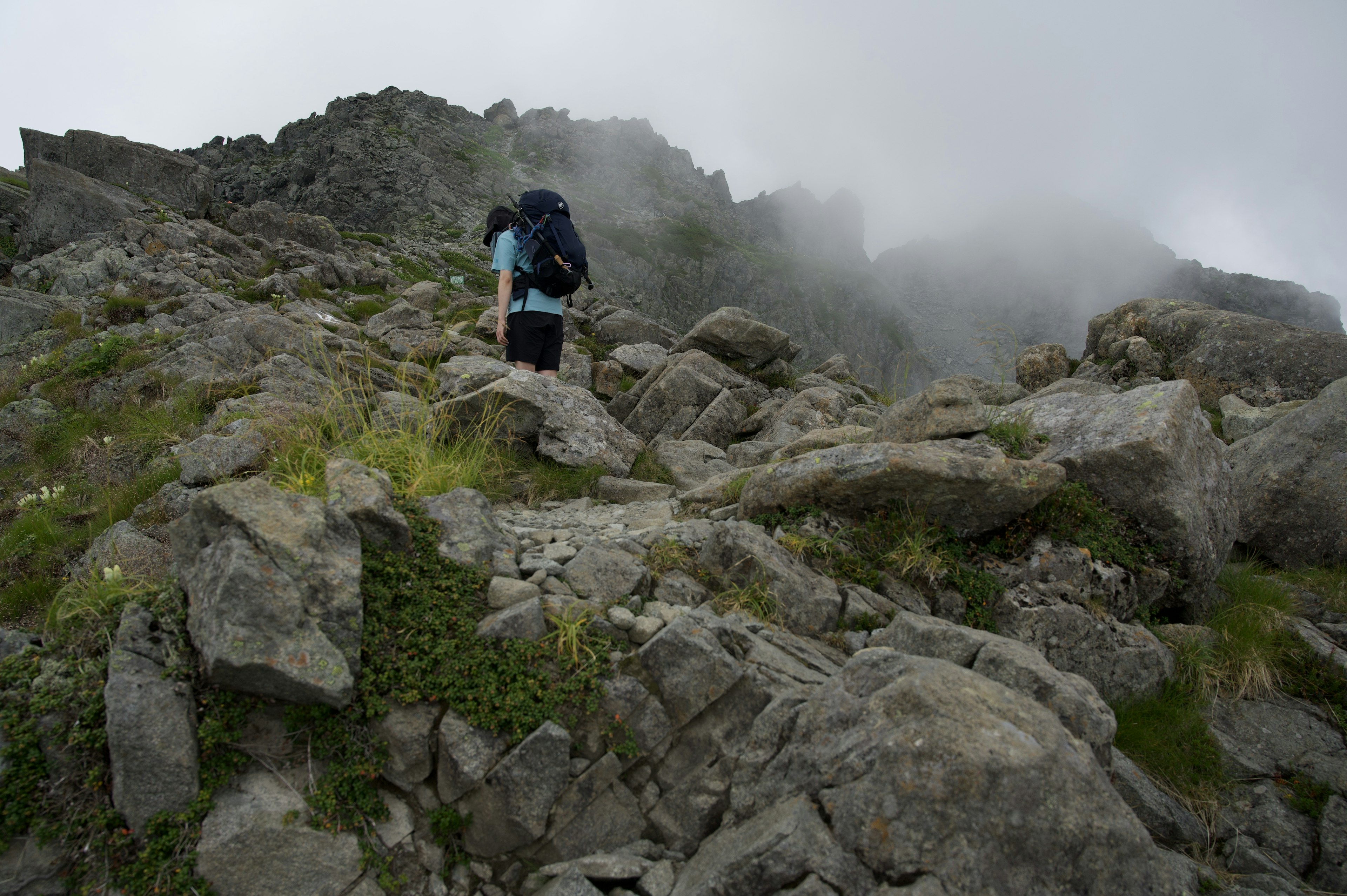 Hiker climbing a rocky mountain trail