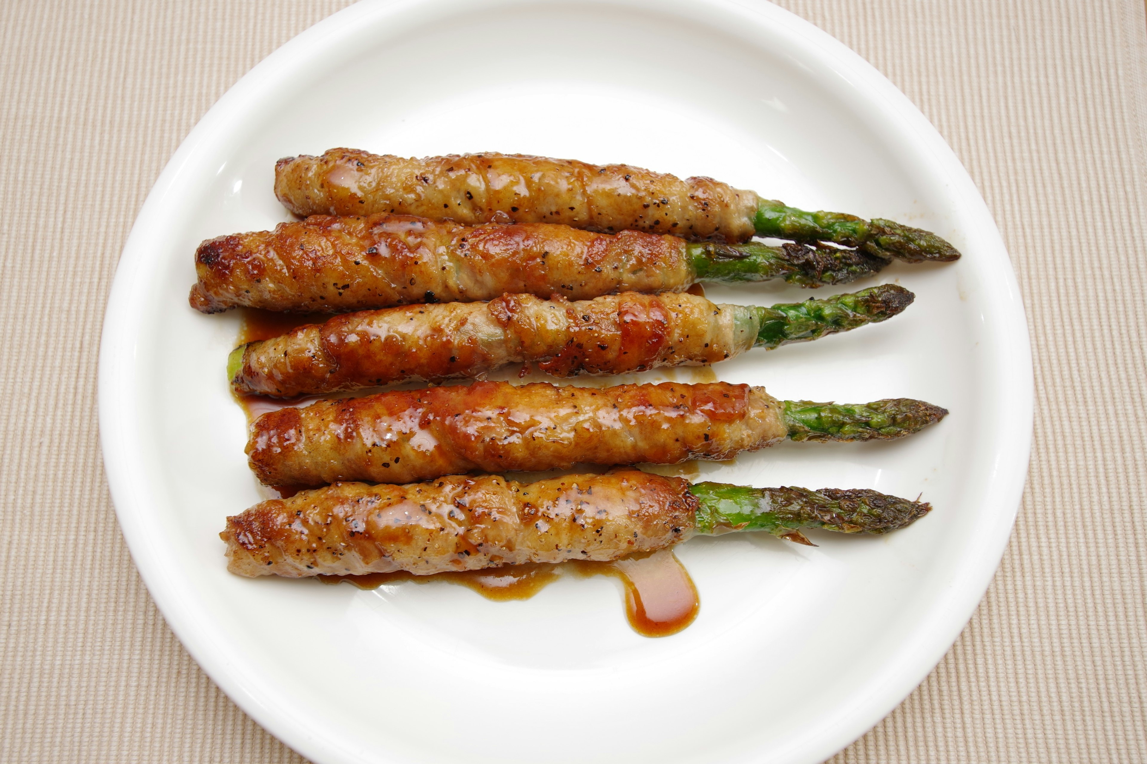 Asperges enroulées de viande servies sur une assiette