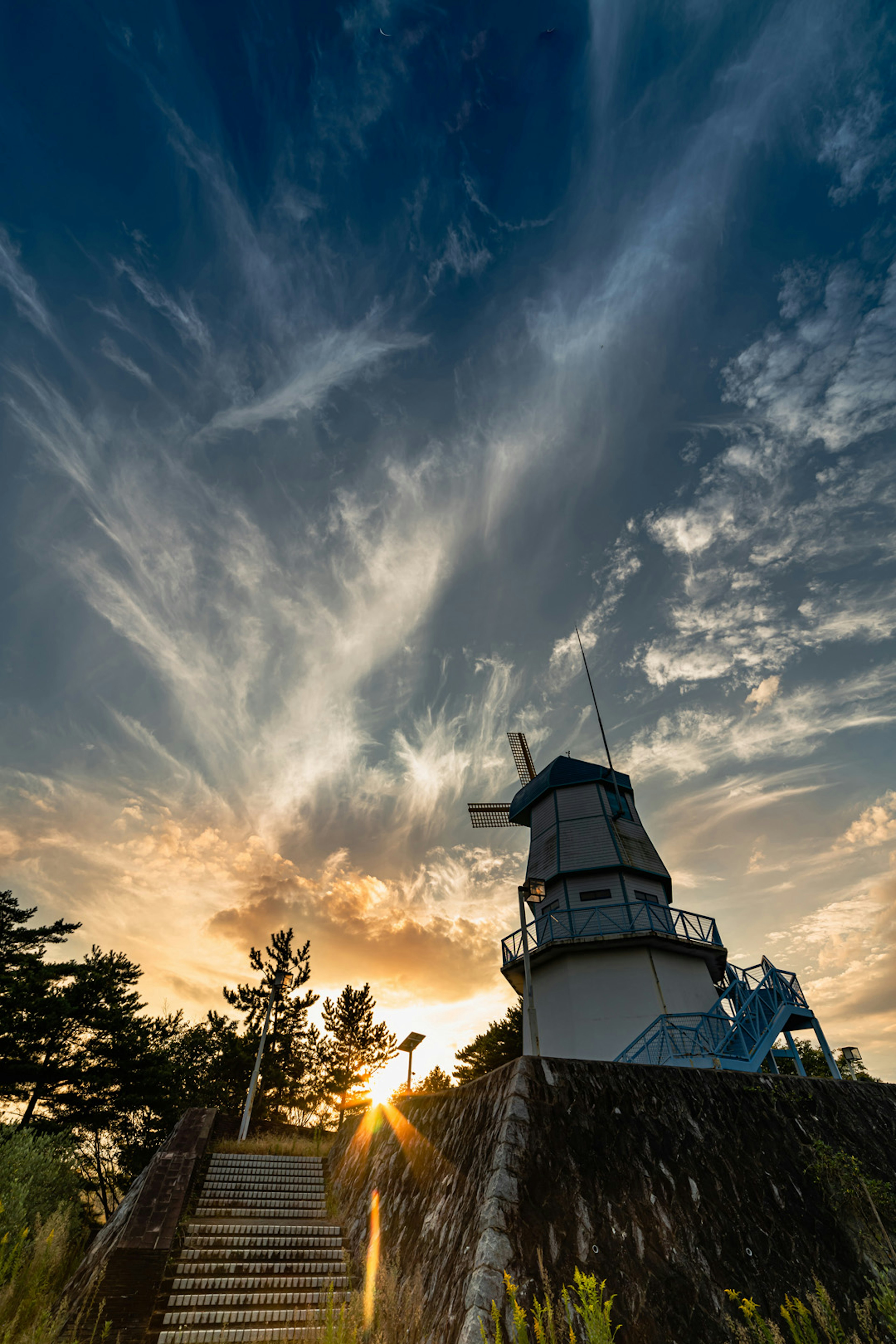 Faro erguido contra un atardecer con nubes dramáticas