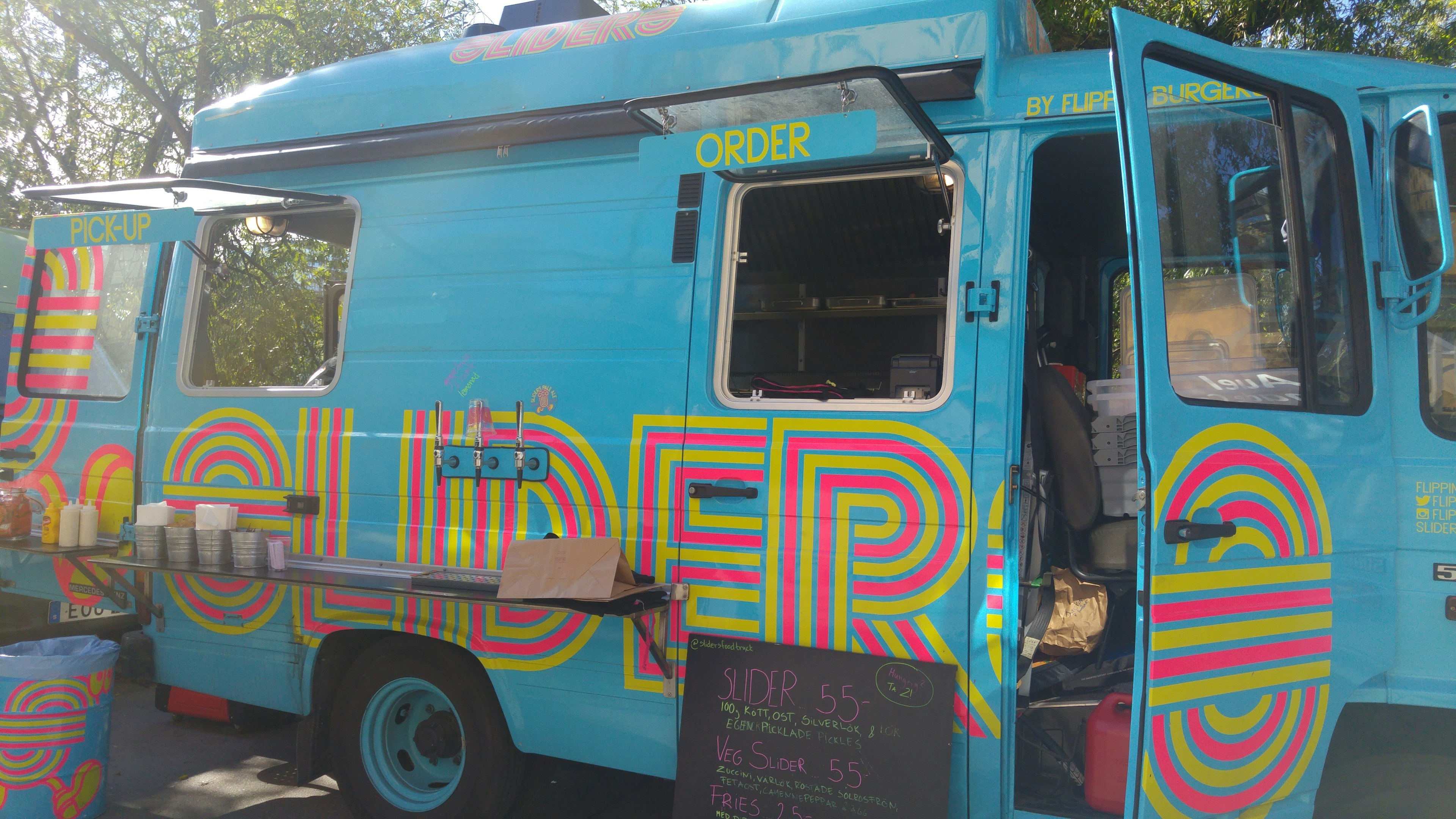 Bright blue food truck with colorful lettering and open window