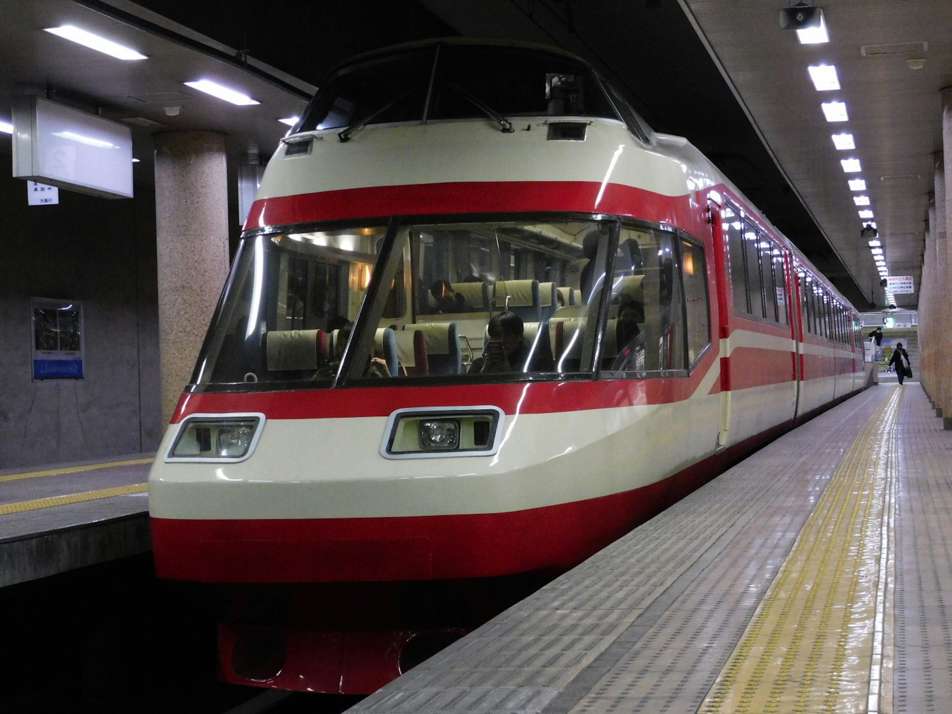 Train express avec des rayures rouges arrêté sur un quai de gare