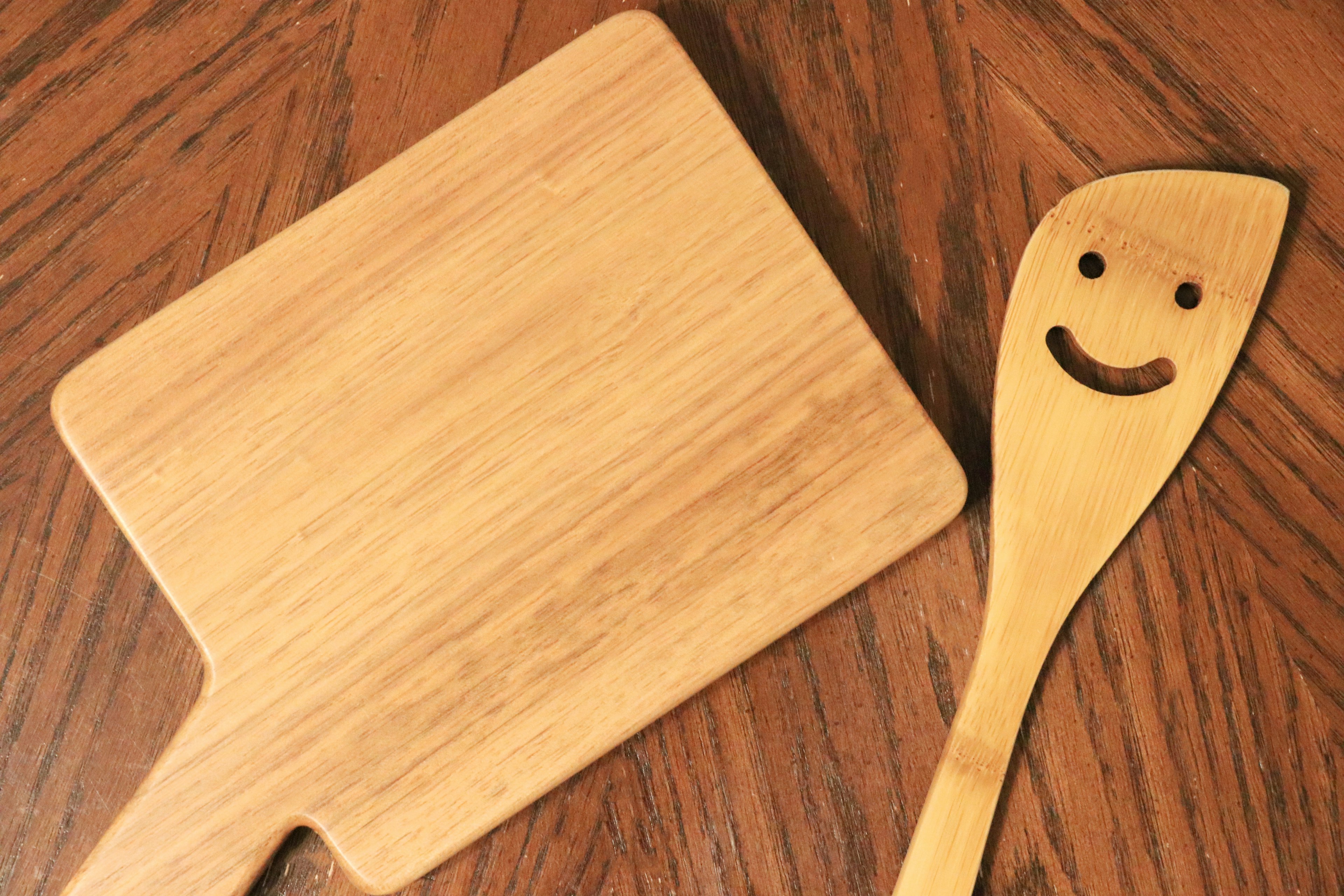 Planche à découper en bois et cuillère souriante placées ensemble