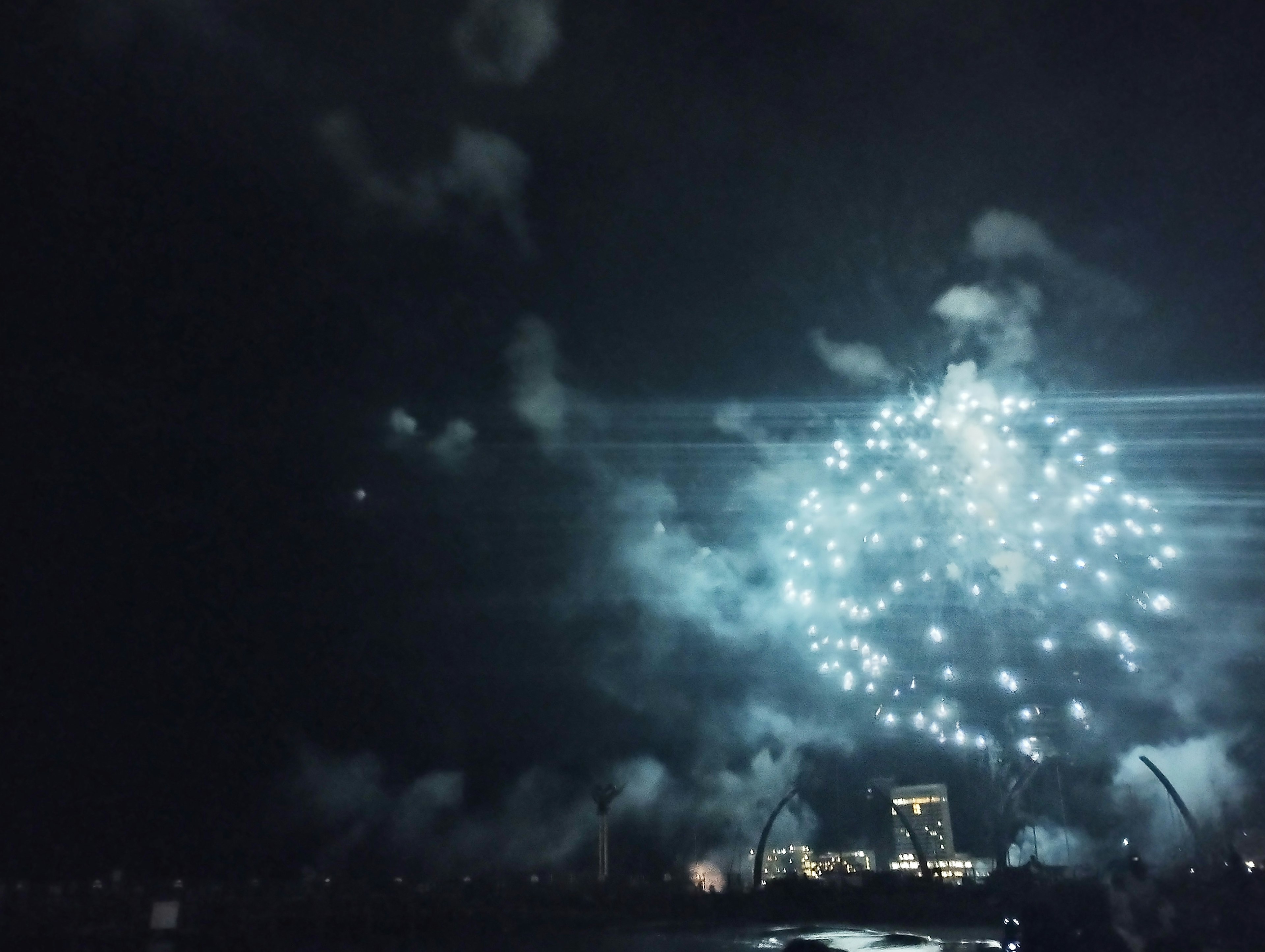 夜空に輝く青い花火と煙