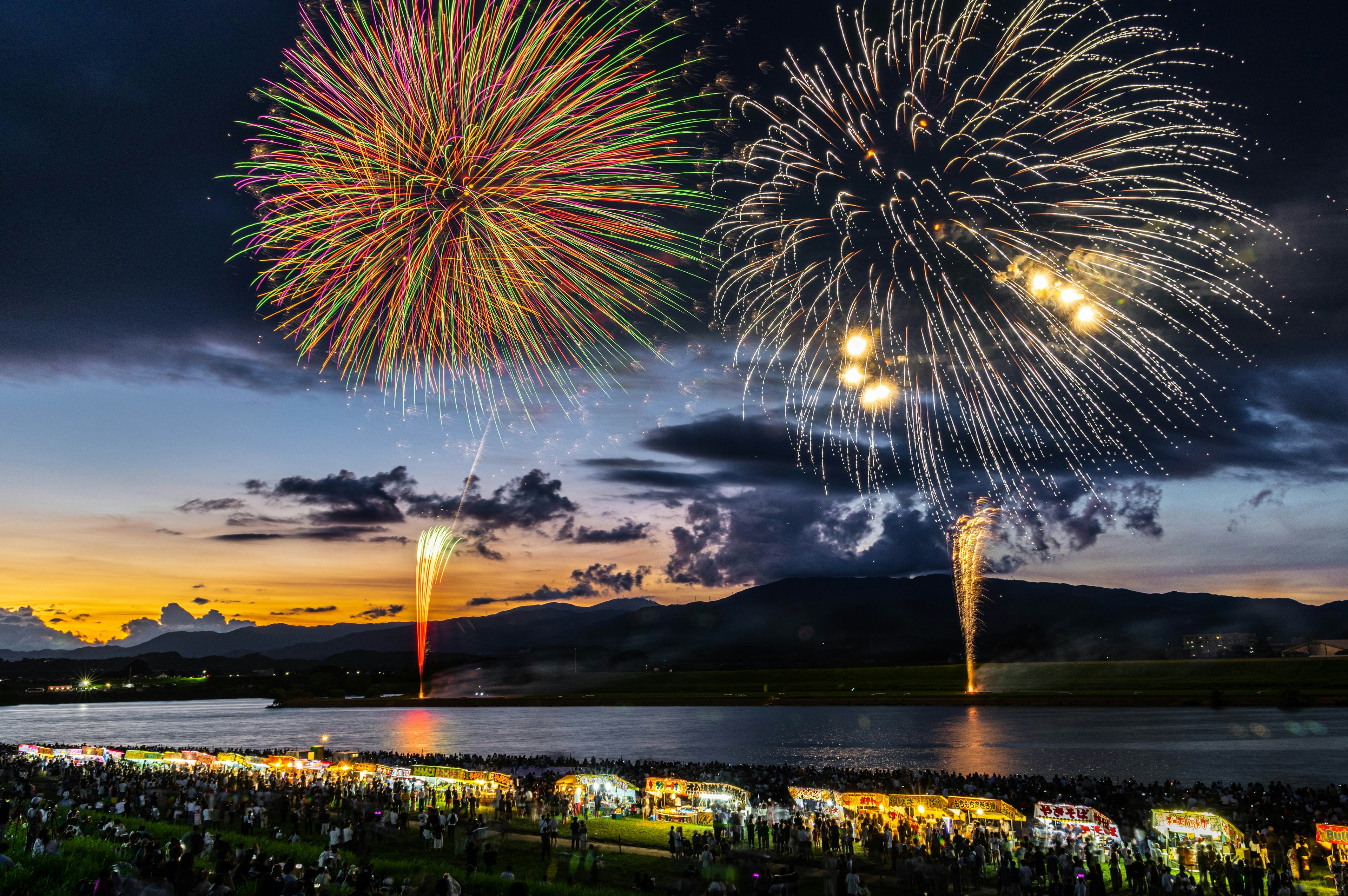 Feux d'artifice spectaculaires illuminant le ciel nocturne au-dessus d'une rivière