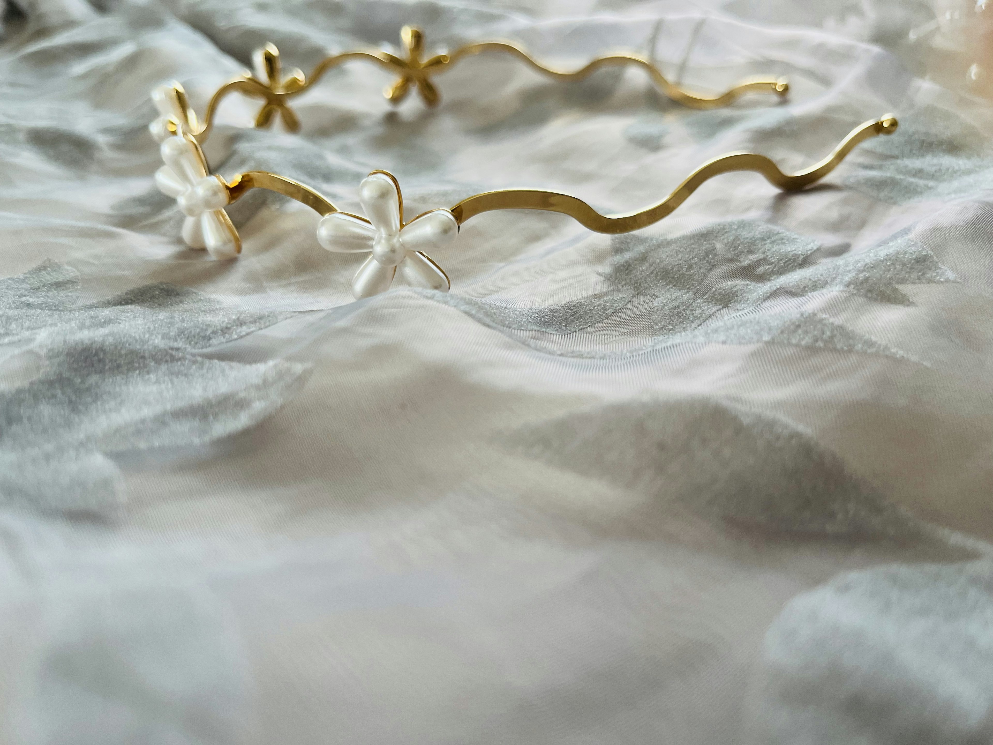 Gold hairband adorned with white floral decorations