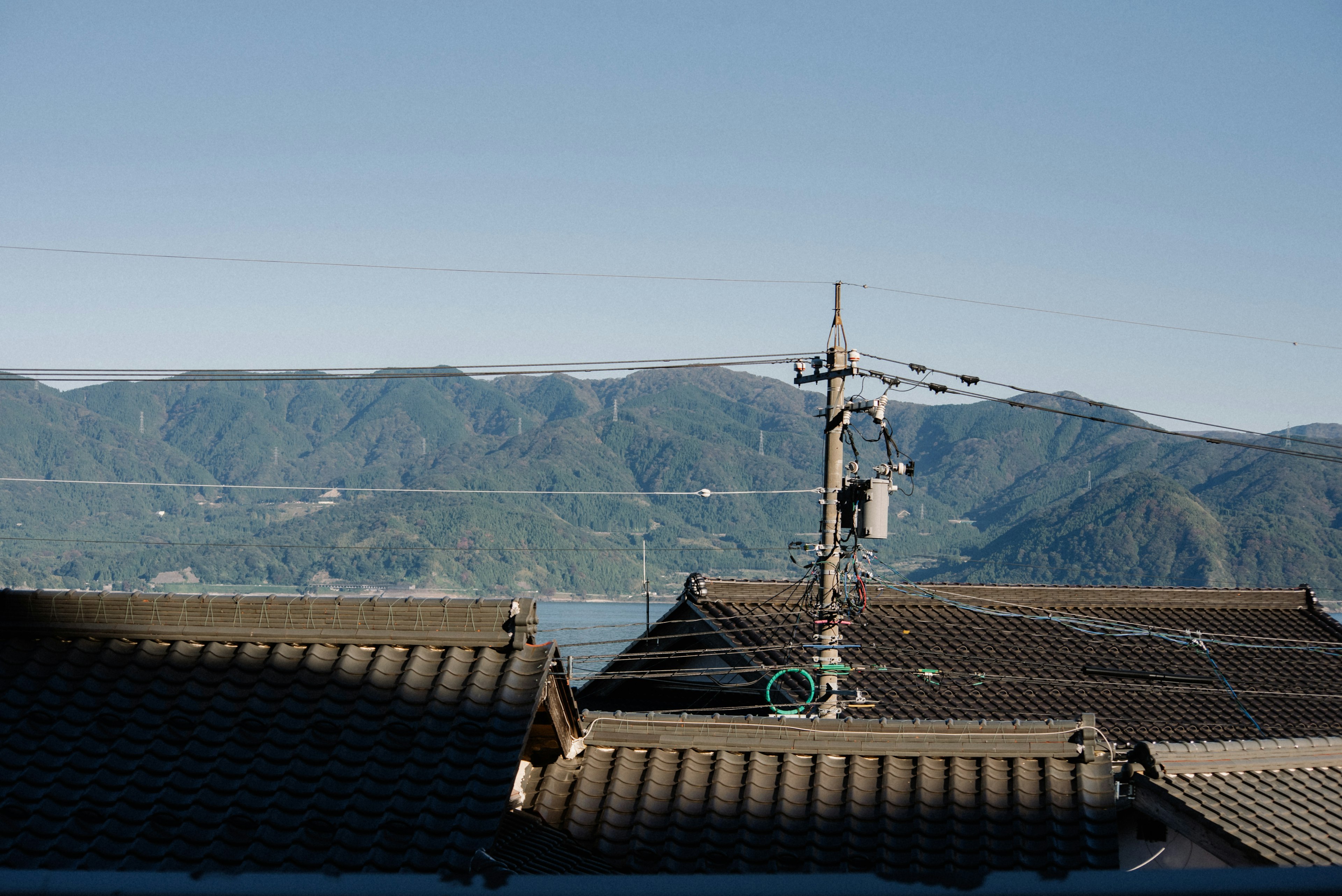 Rooftops and utility pole with mountains in the background