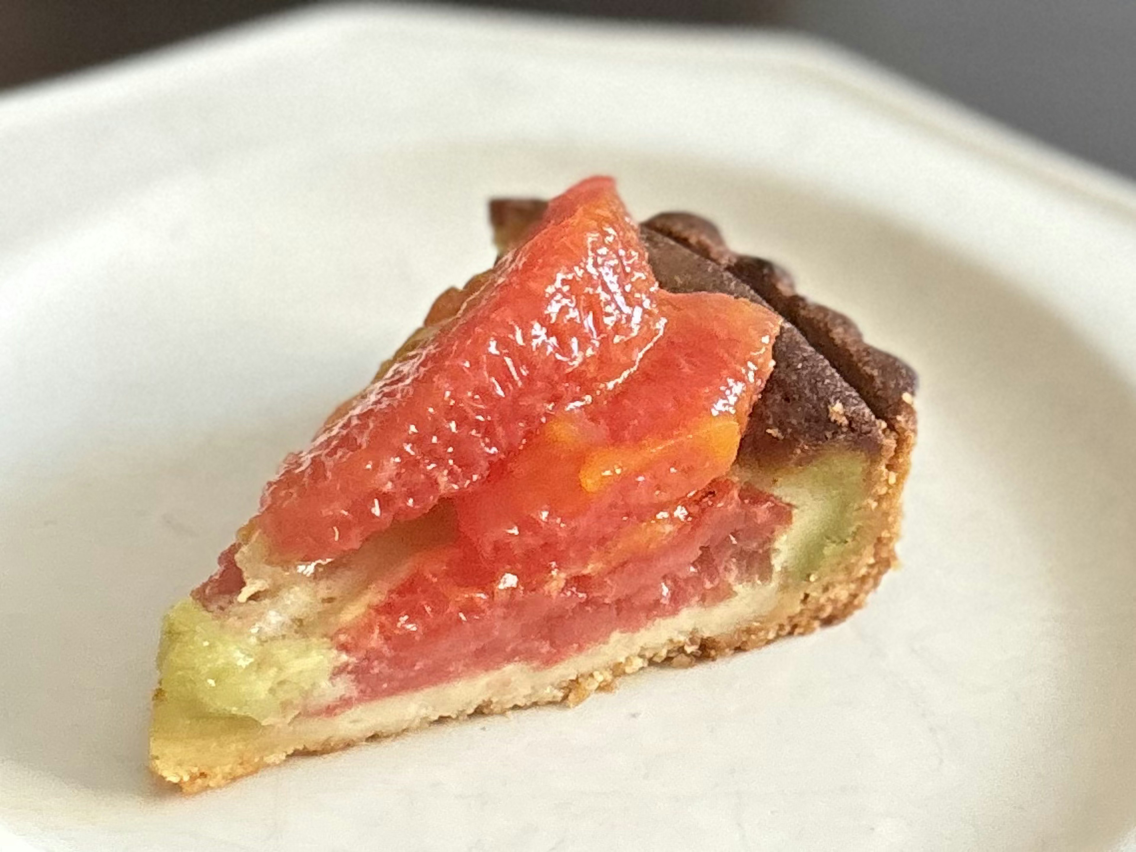 A slice of tomato tart displayed on a white plate