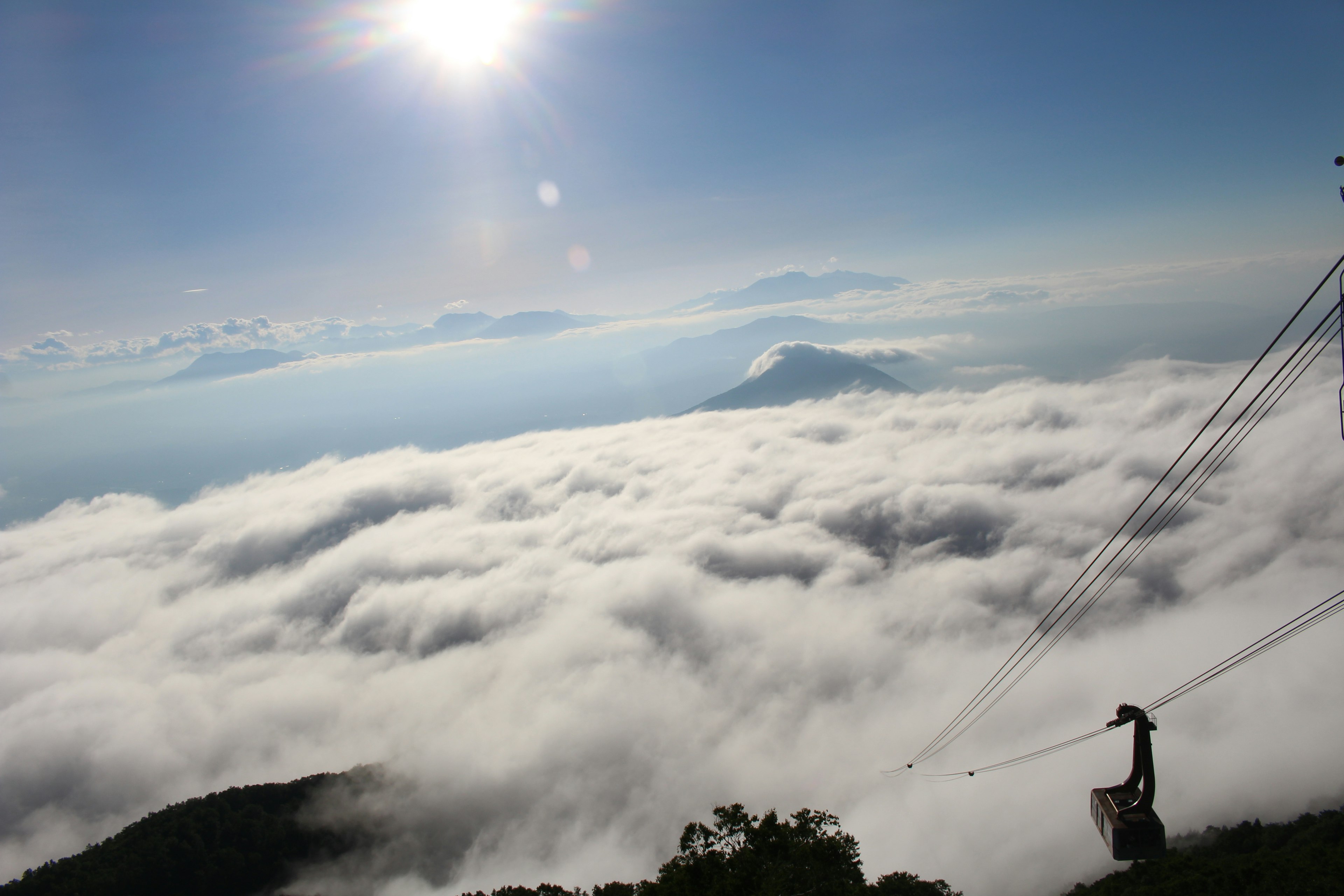 Landscape above a sea of clouds with blue sky and sunlight