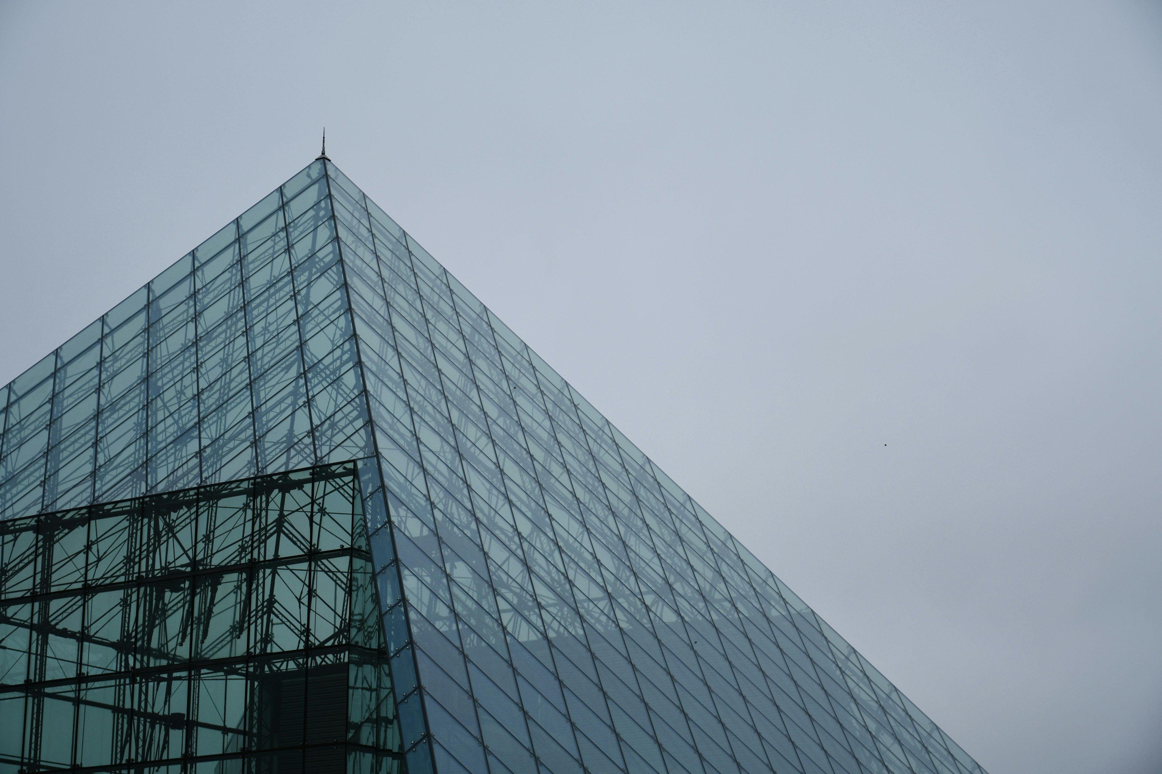 Parte superiore di un edificio a forma di piramide di vetro con un angolo acuto