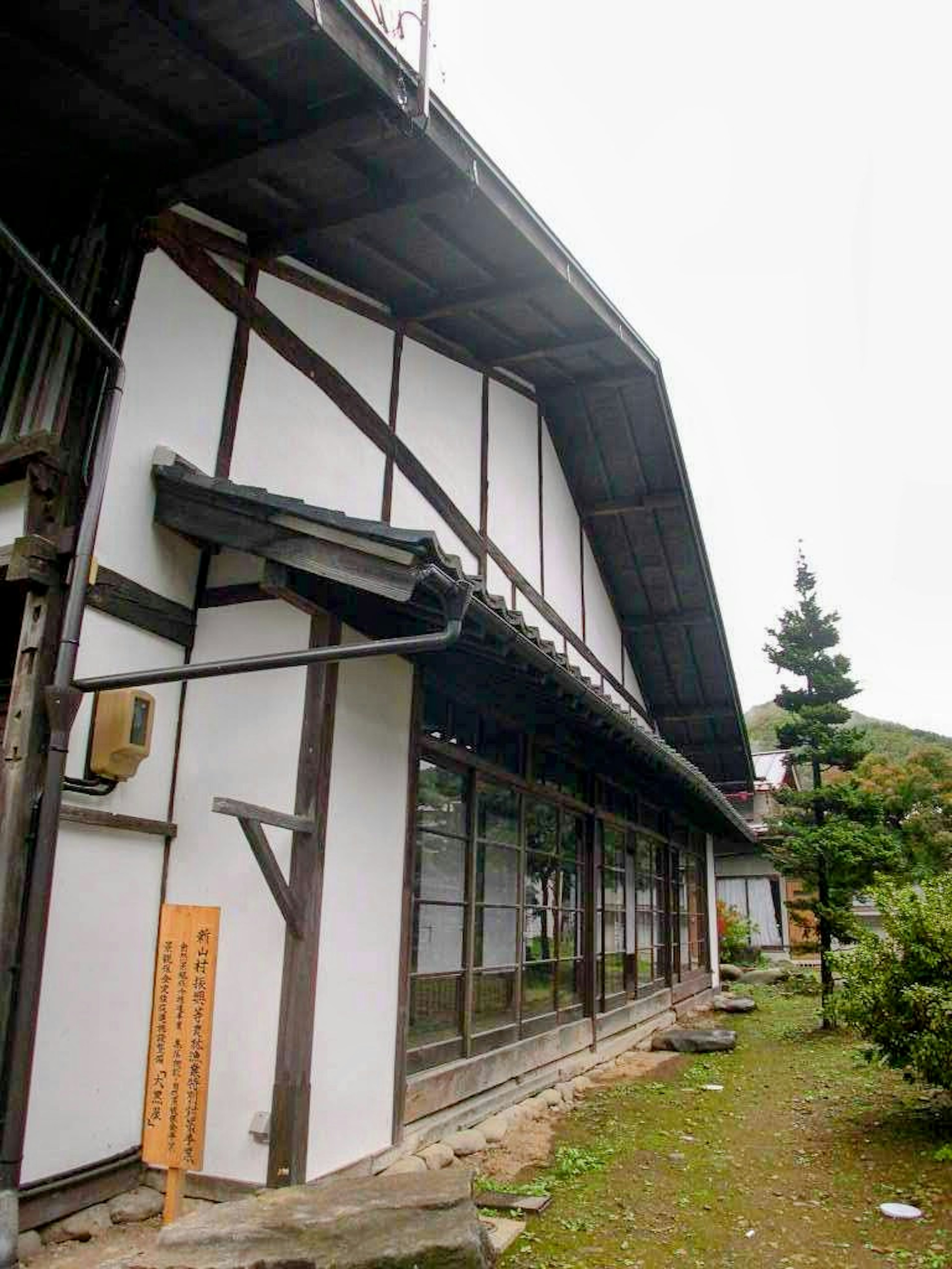 Vue extérieure d'une maison japonaise traditionnelle avec de nombreuses fenêtres et un toit en pente