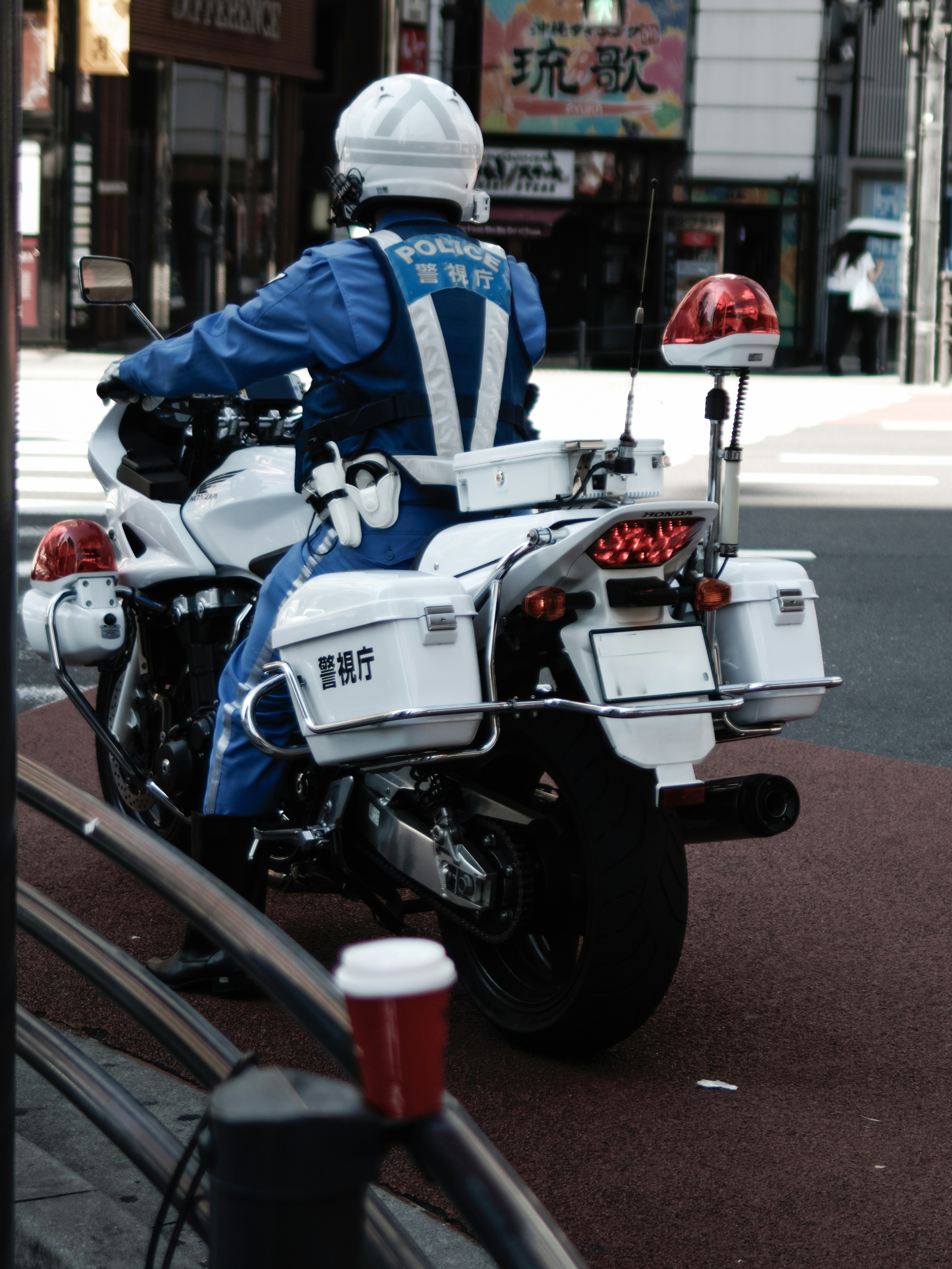 Un poliziotto in uniforme blu che guida una moto bianca