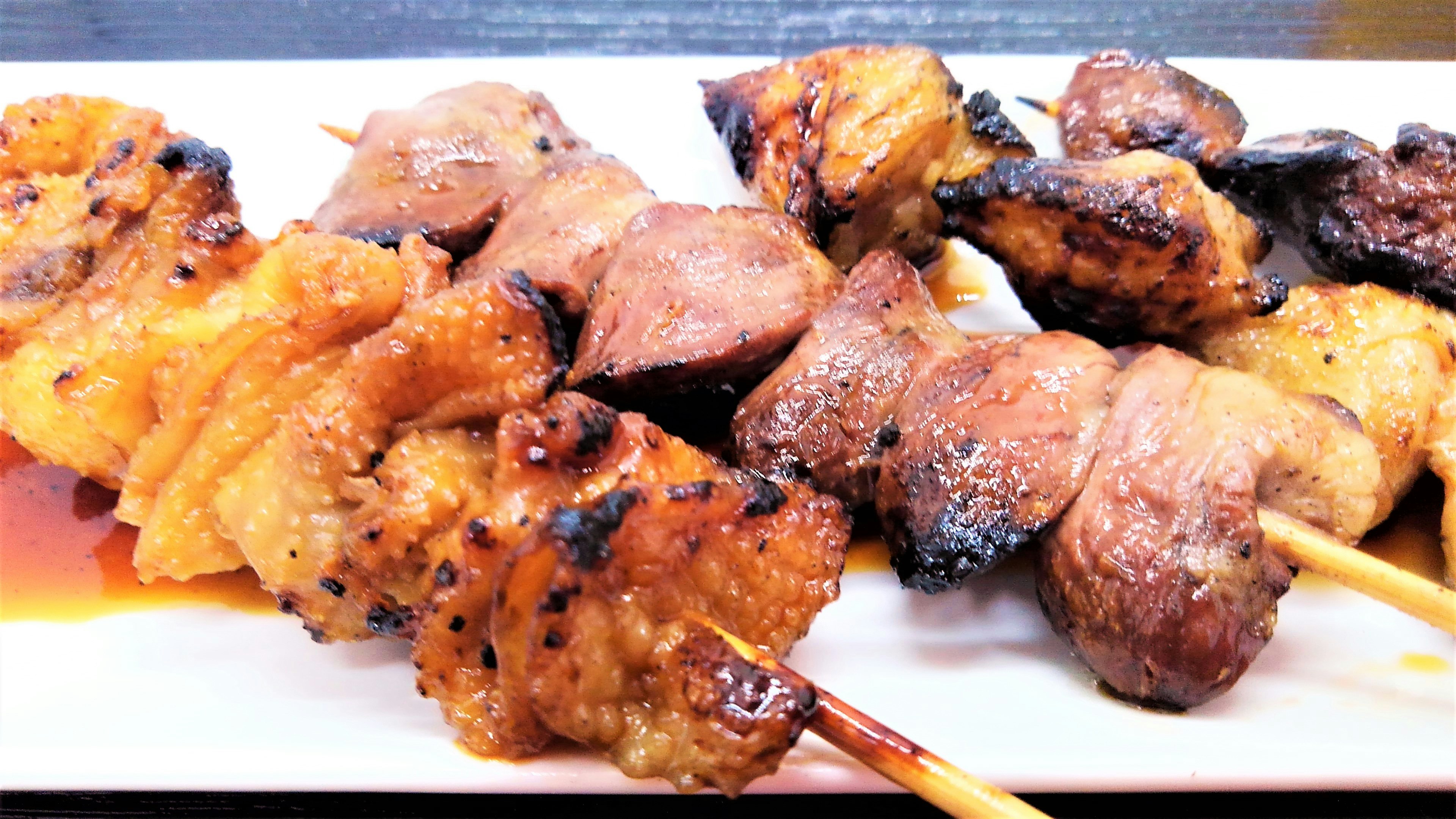 Brochetas de yakitori deliciosamente presentadas con pollo a la parrilla y glaseado sabroso