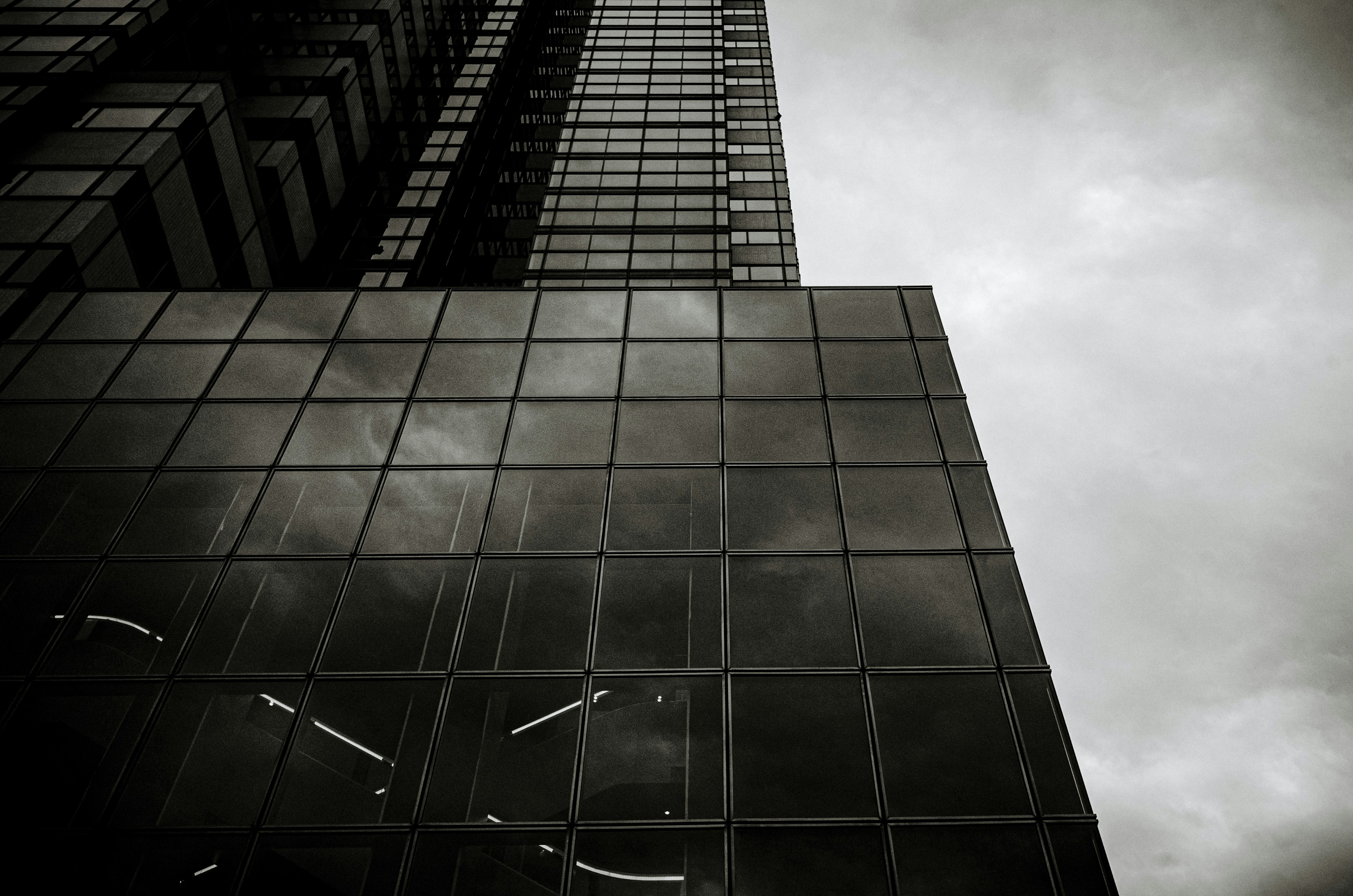 Hochhaus mit Glasfassade und bewölktem Himmel