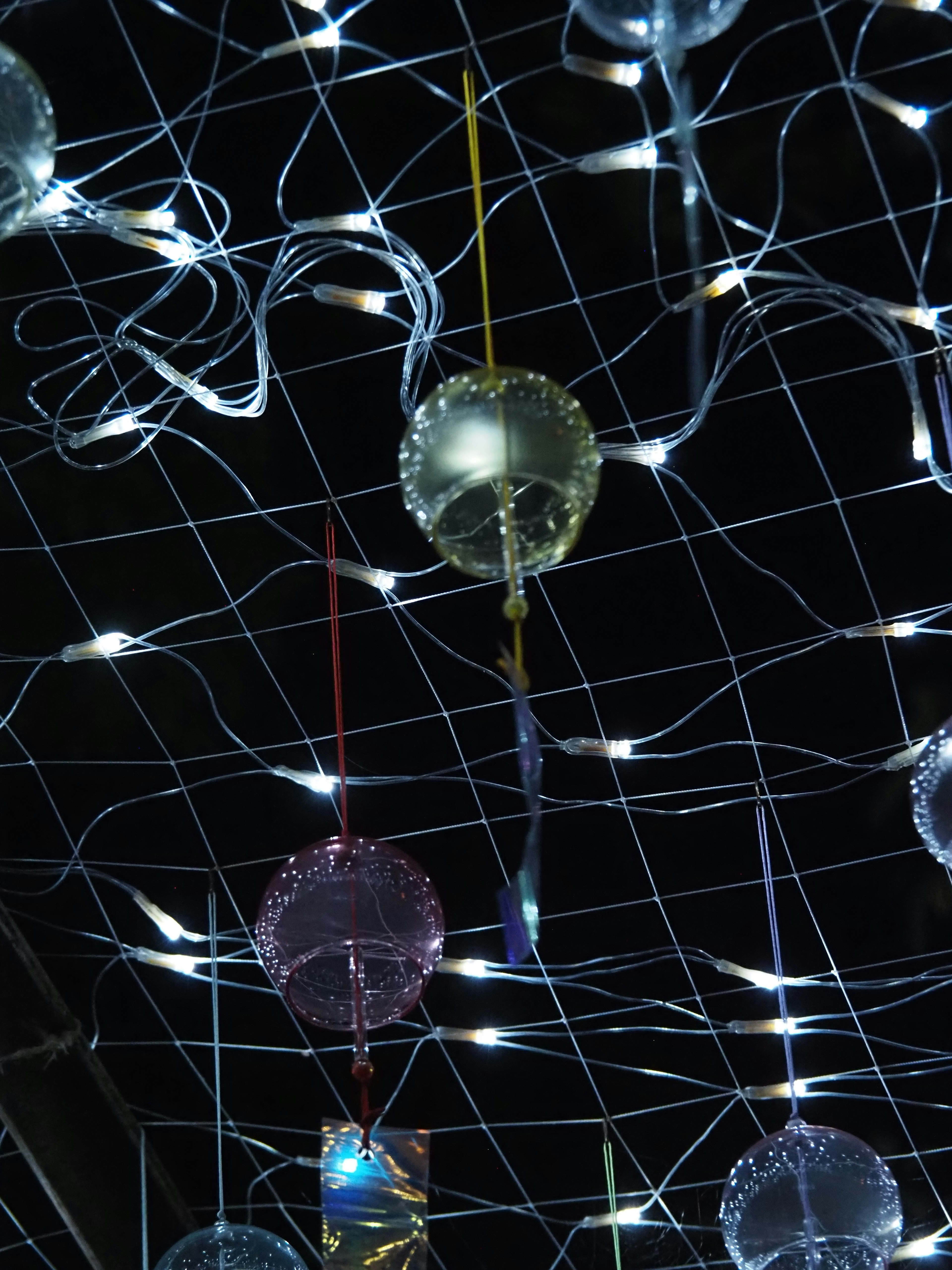 Colorful balloons illuminated by lights against a dark background