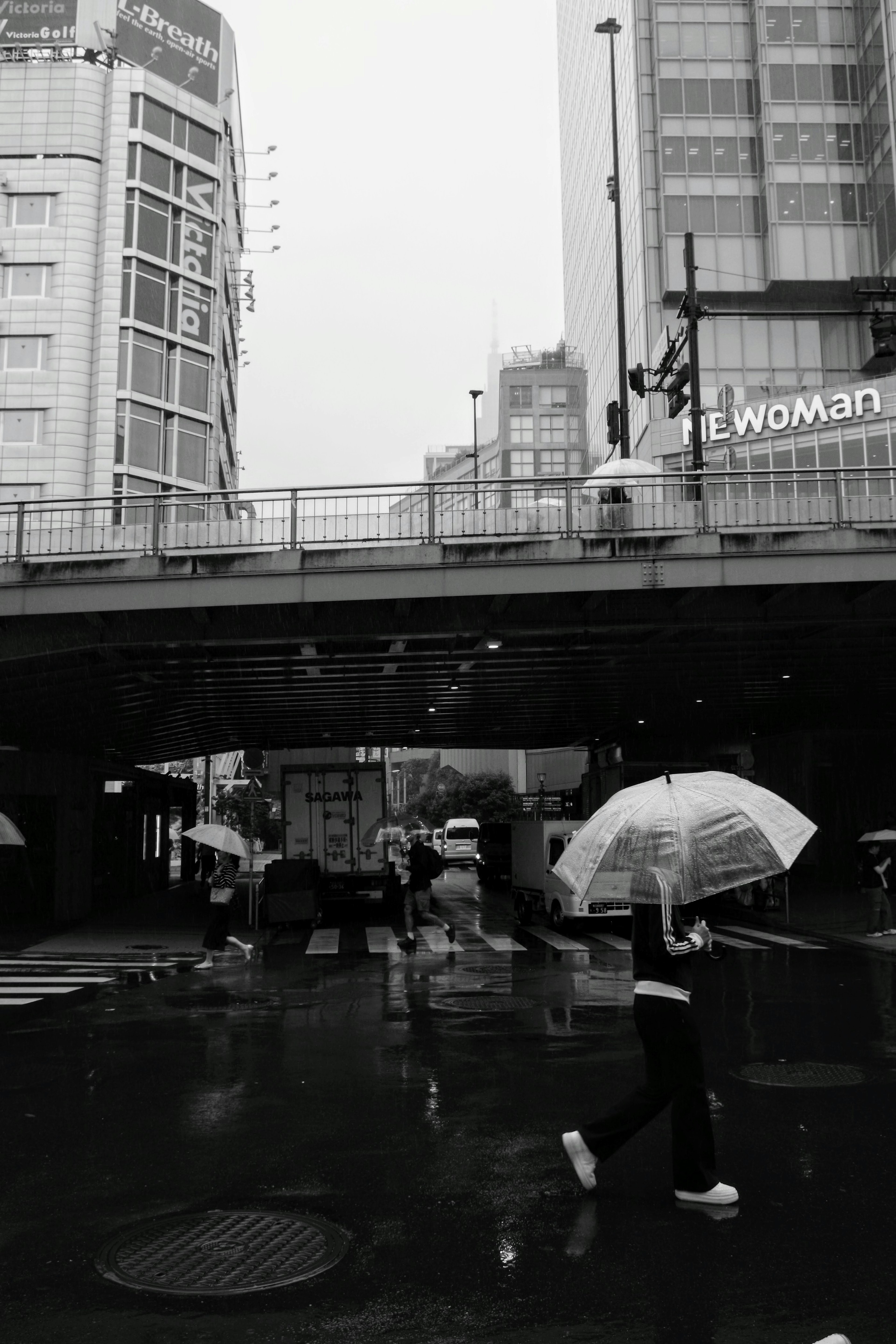 Urban scene with people carrying umbrellas in the rain