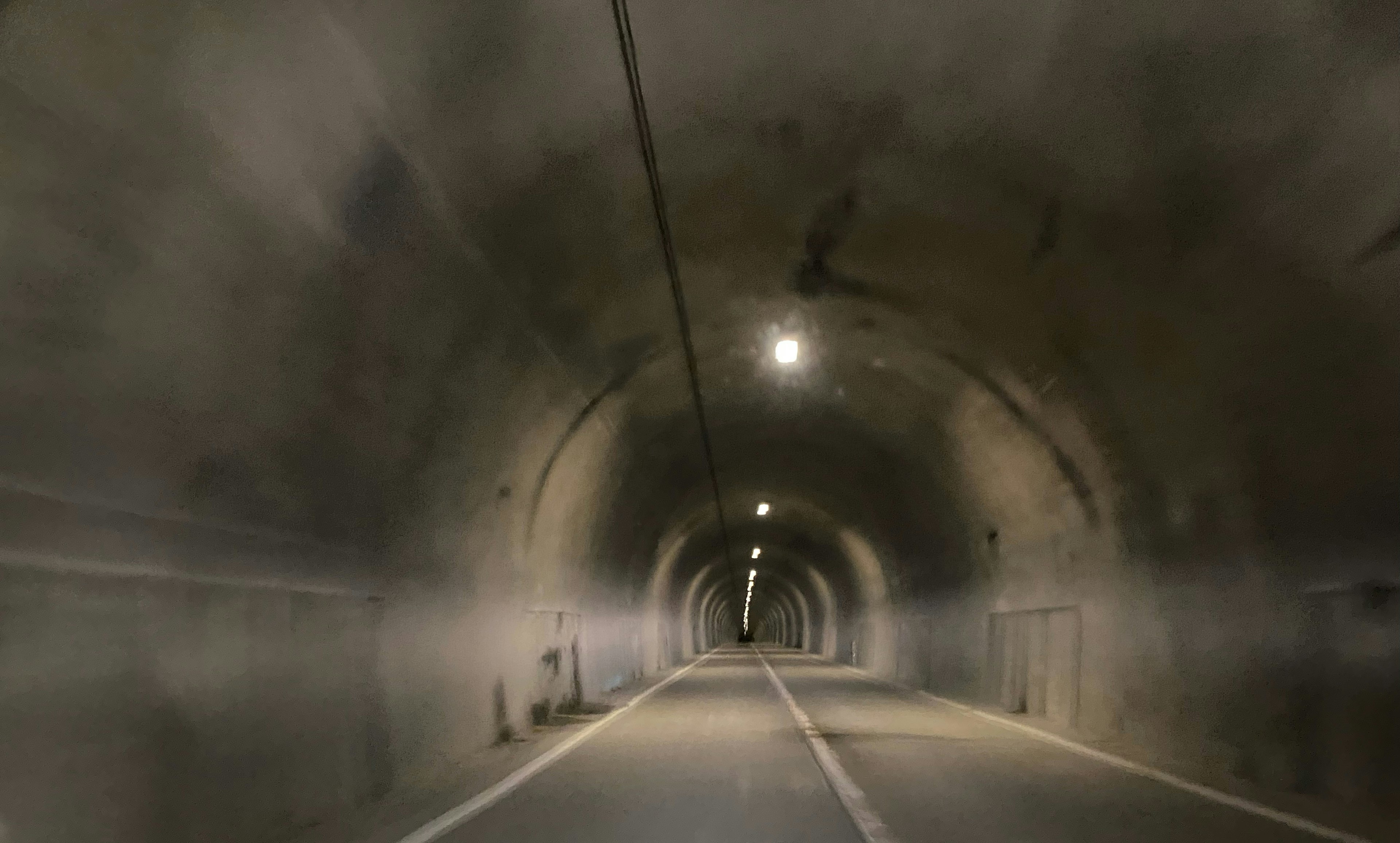 Vista interior de un túnel con luces brillantes que iluminan el pasaje oscuro